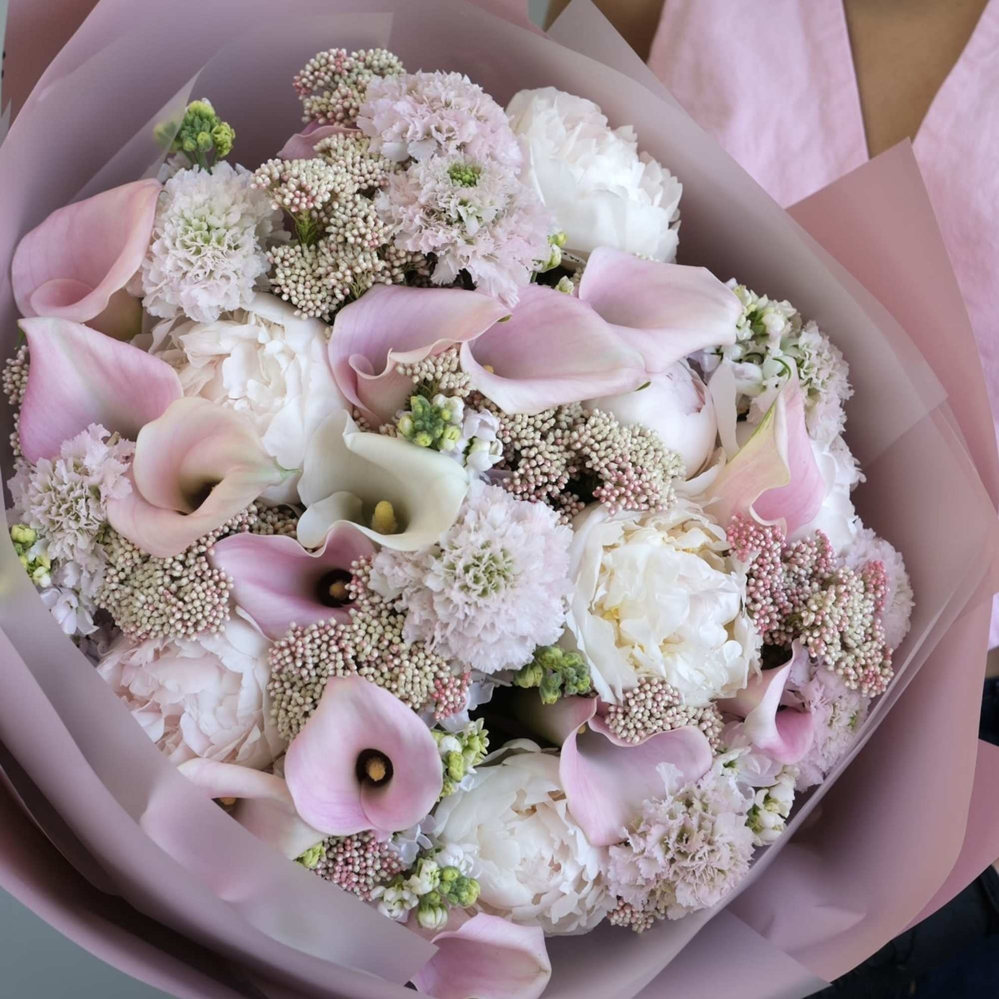 Pink and white bouquet with calla lilies and peonies wrapped in pink paper