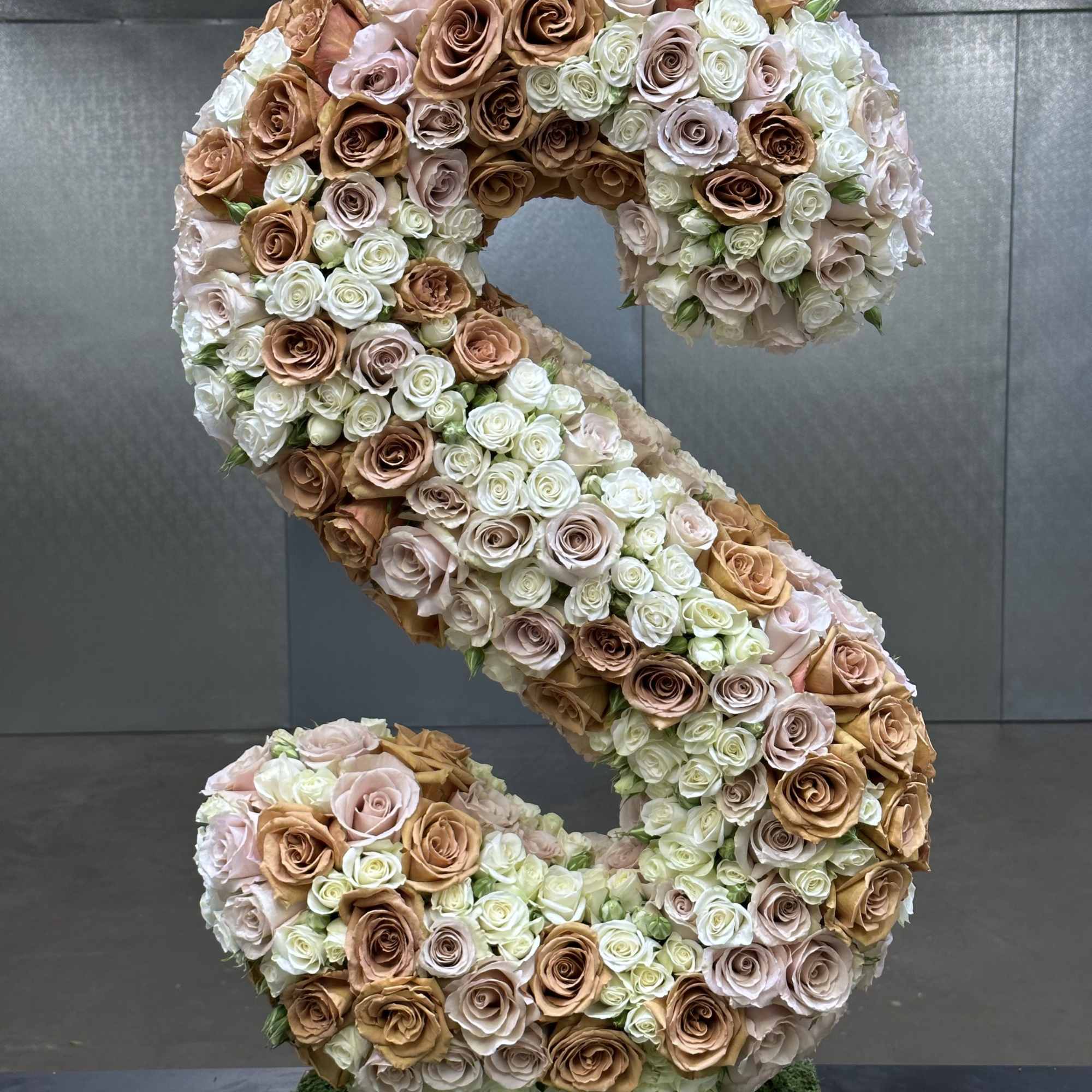 Large S-shaped rose arrangement in blush, cream, and tan tones