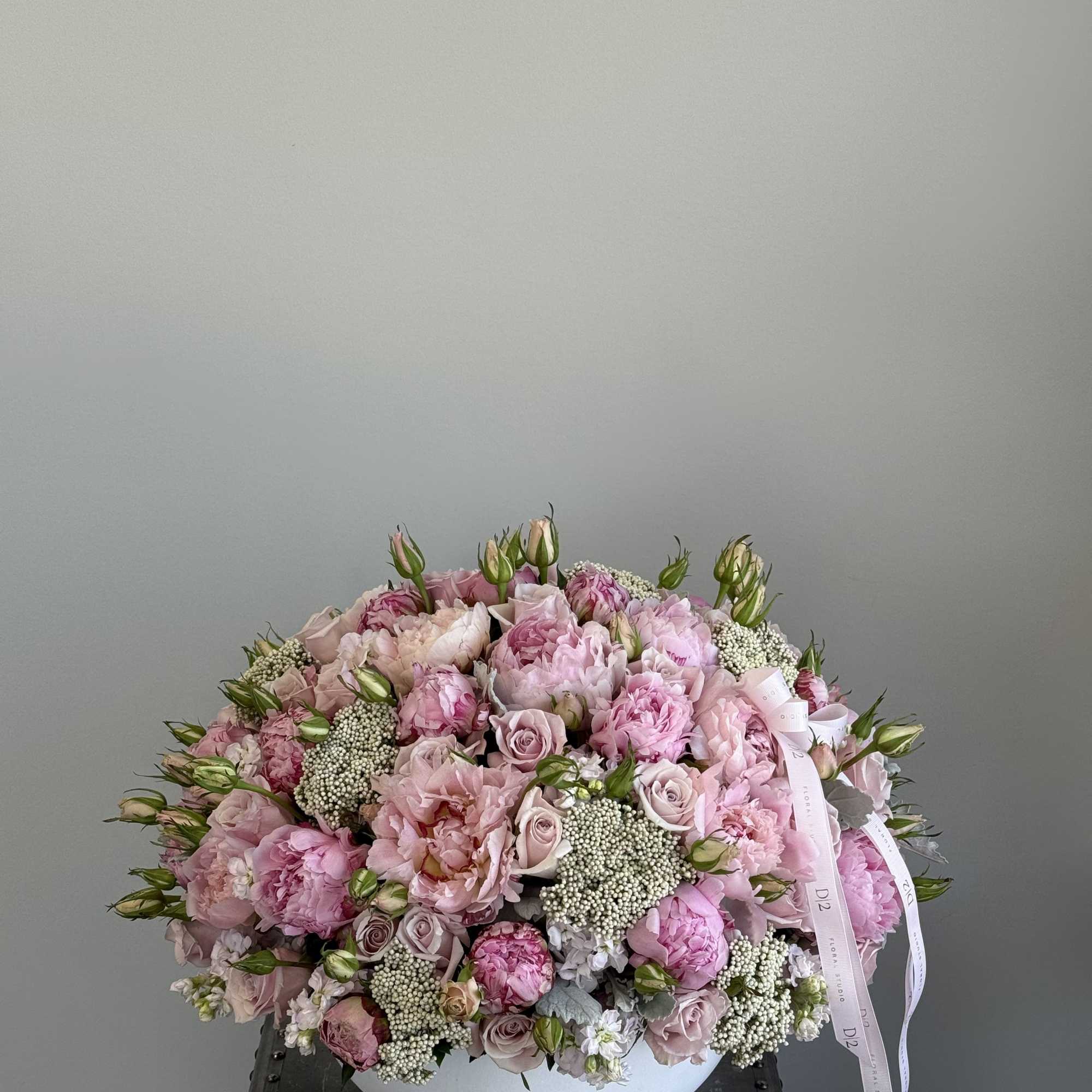 Large pink bouquet of roses and peonies in a white bowl