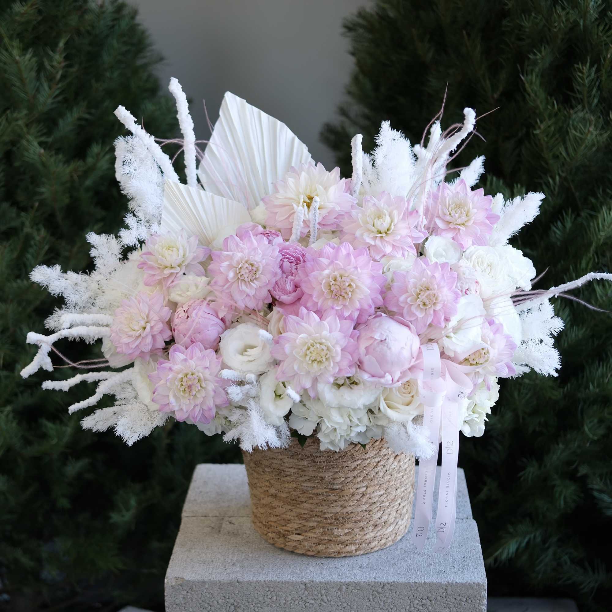 Pink and white bouquet in a woven basket