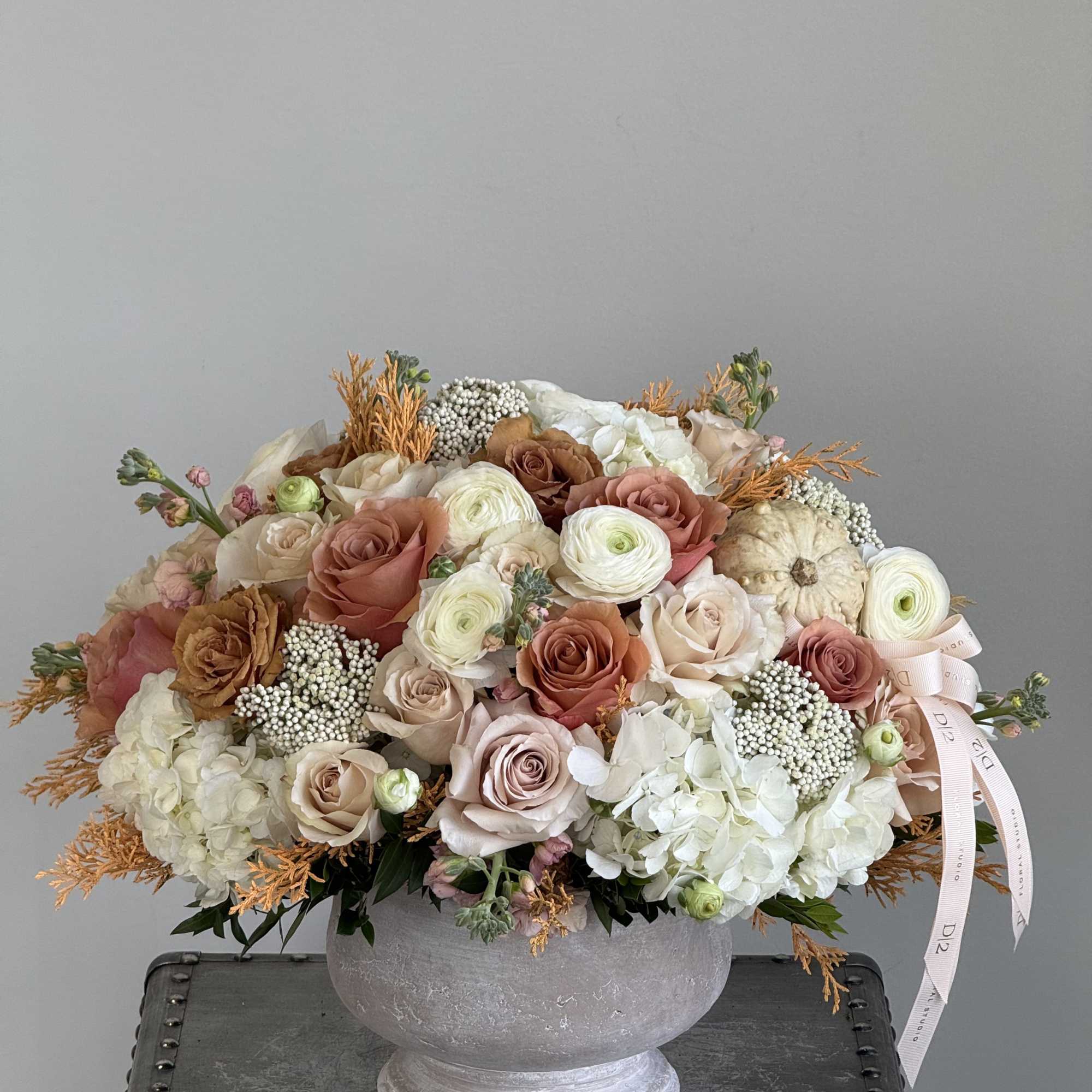 Large pastel rose and hydrangea arrangement in a gray urn