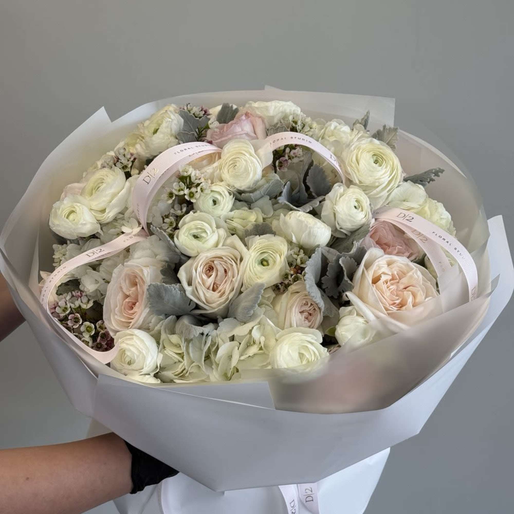 Bouquet of pale pink and white roses with ribbon accents
