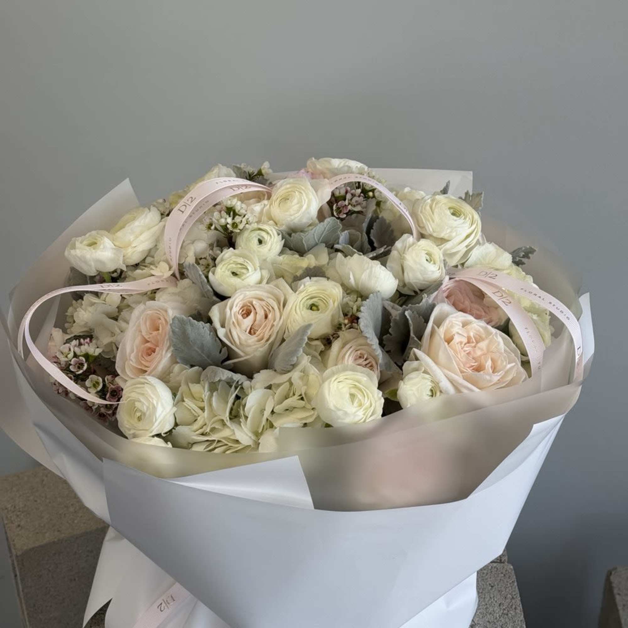 Bouquet of cream and blush flowers wrapped in white paper