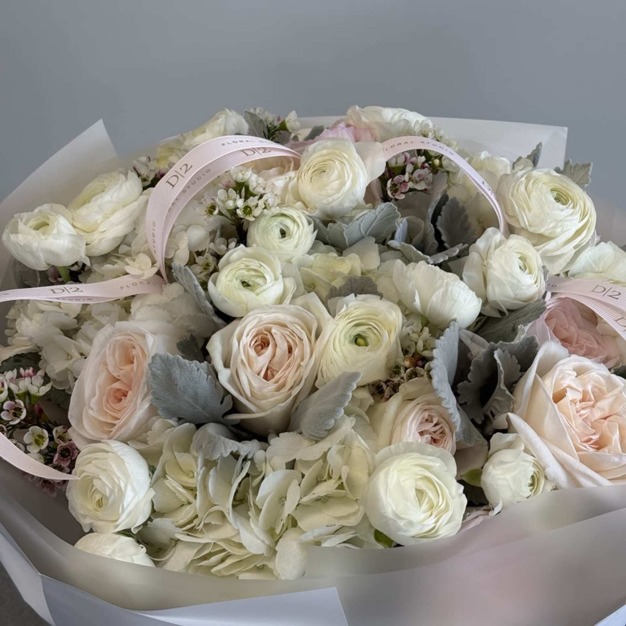 Bouquet of white and blush roses with pale hydrangea in wrapping paper