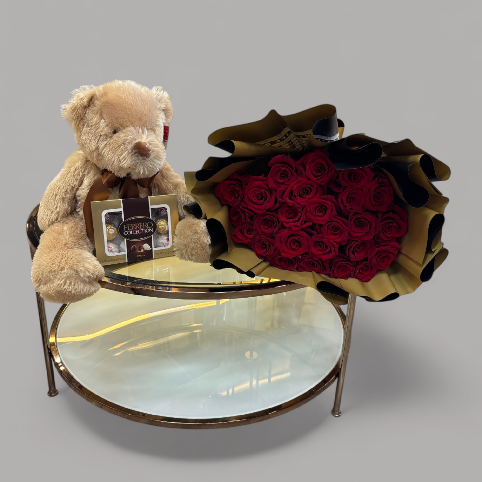 Red rose bouquet with a teddy bear and chocolate box on a round table
