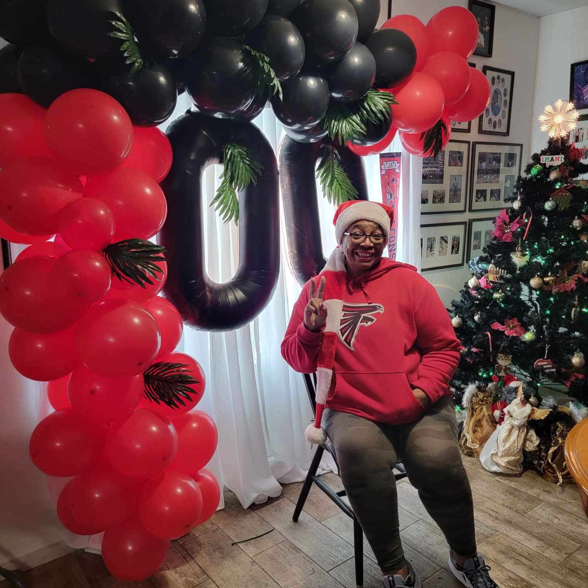 Black and red balloon arch with large number balloons in a room