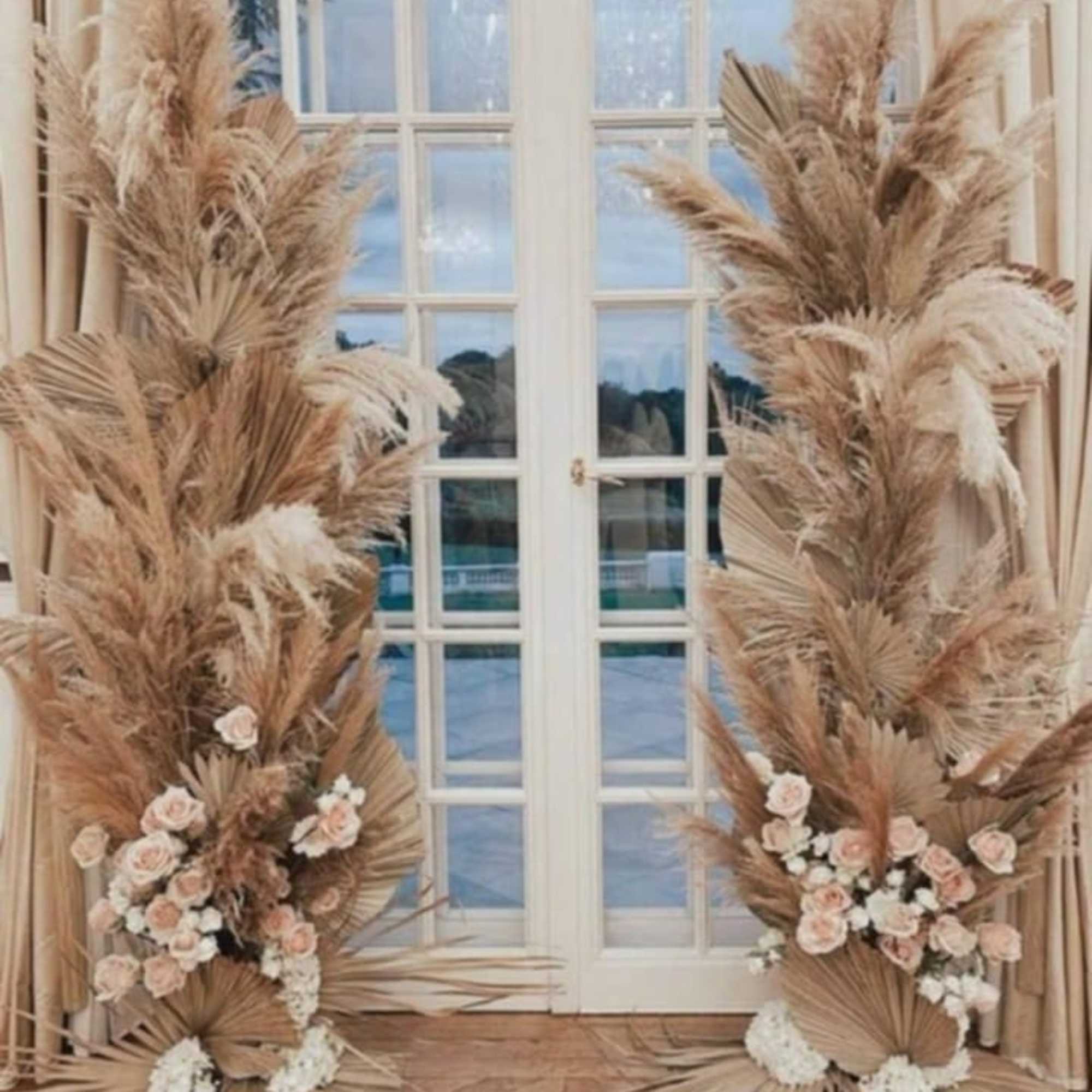Tall dried palm and pampas arrangements with small blush roses by French doors