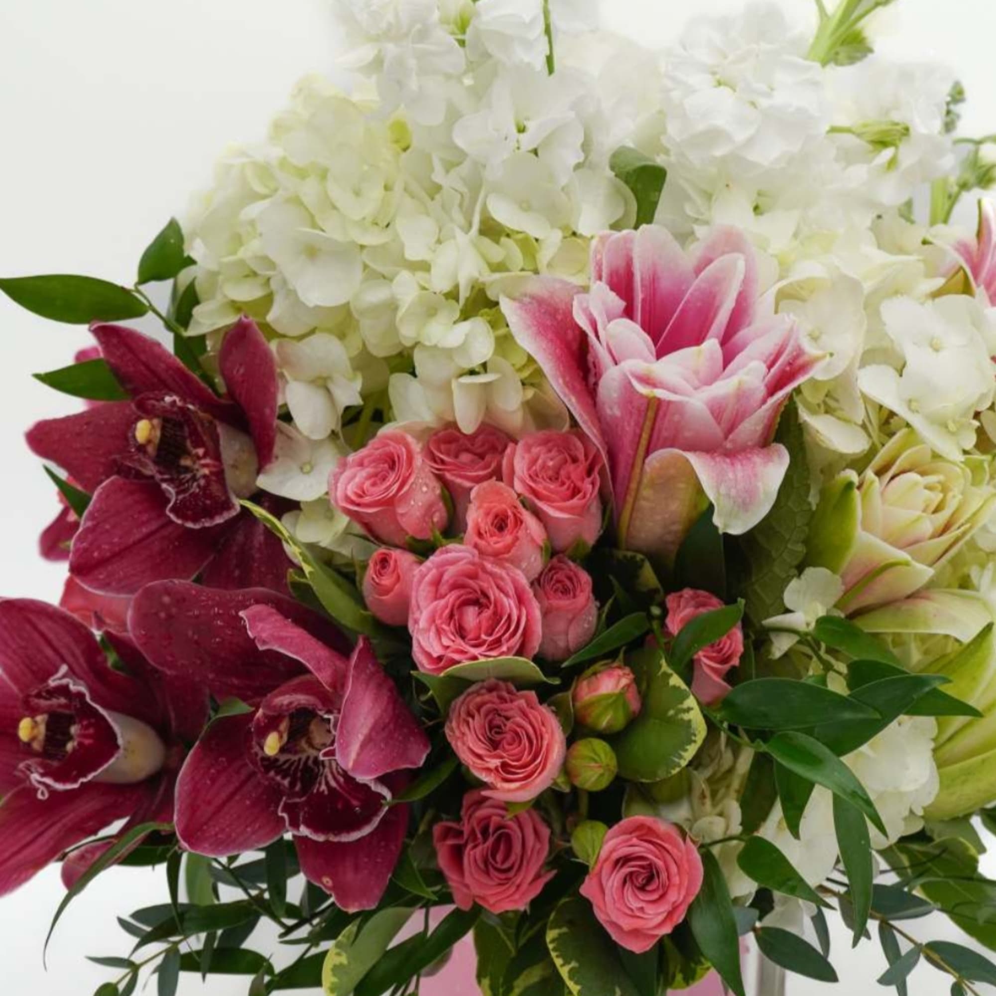Pink roses and orchids arranged with white hydrangeas in a bouquet
