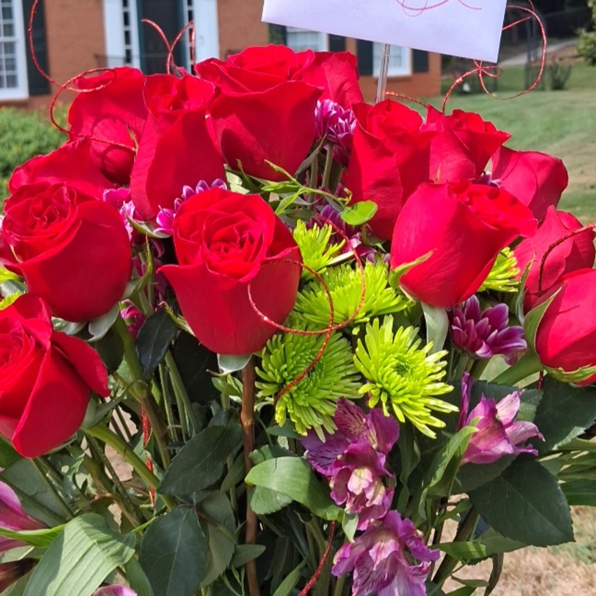 Bouquet of red roses with purple accent flowers and green chrysanthemums