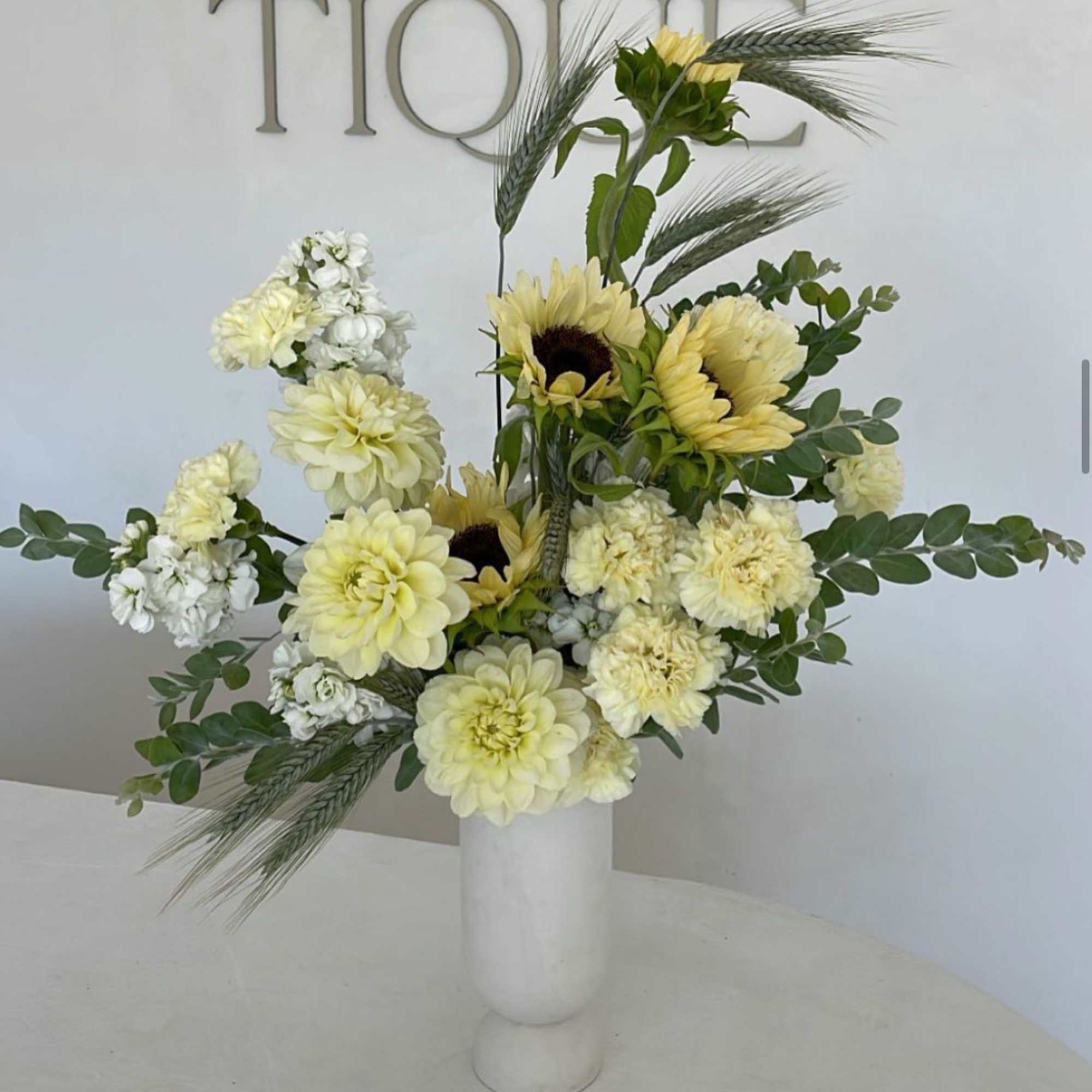 Yellow and white floral arrangement in a white vase