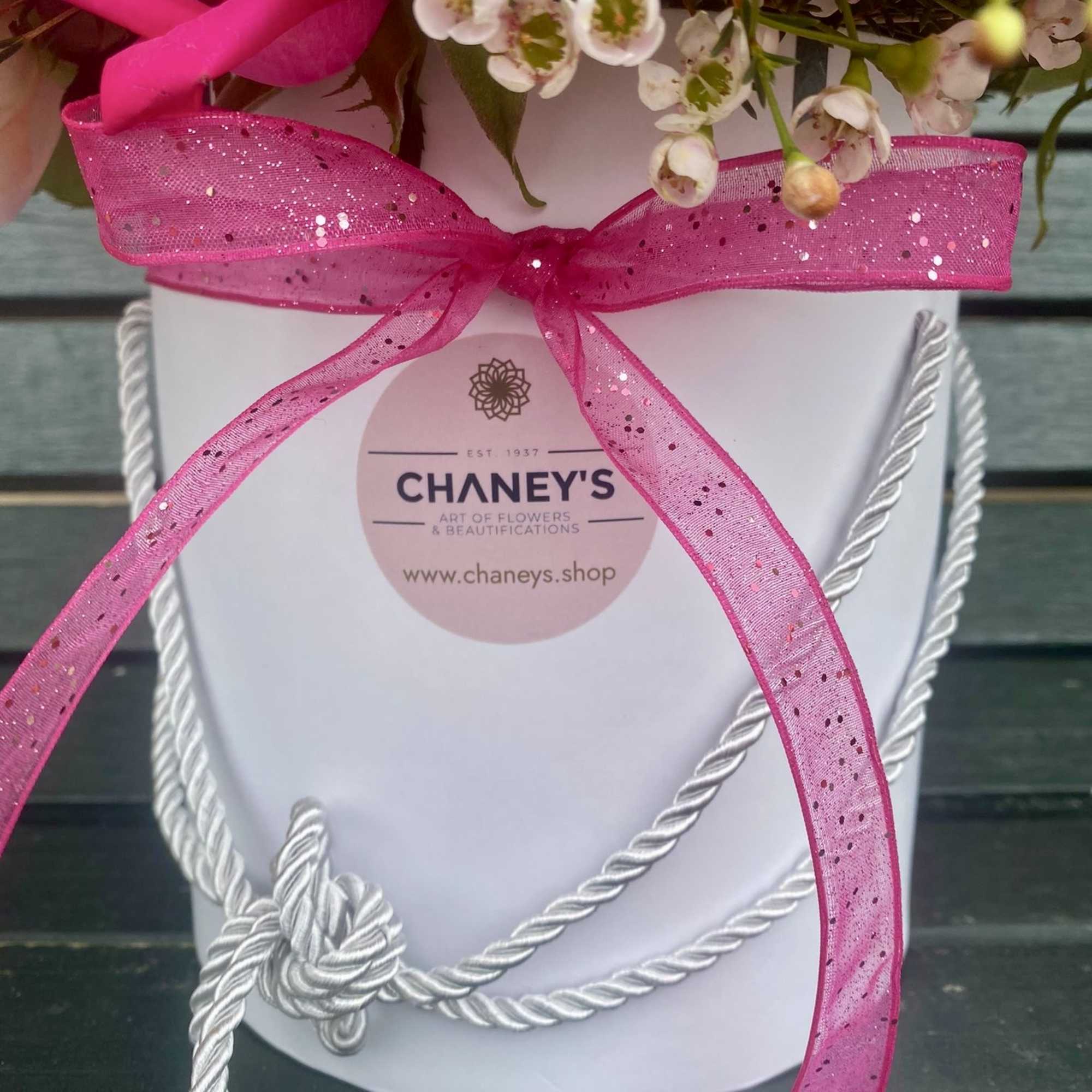 Pink and white flowers in a white gift box with a bright pink ribbon