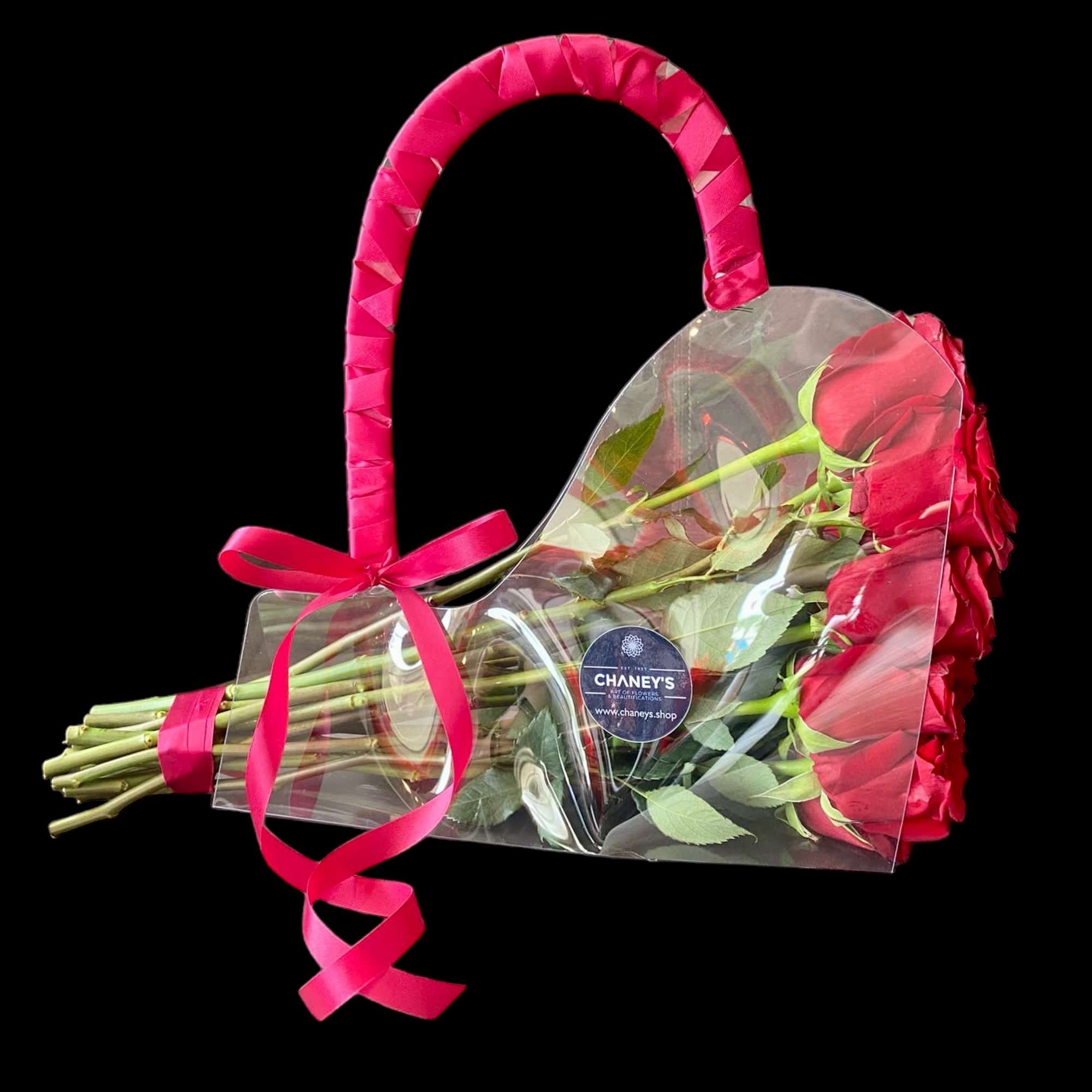 Heart-shaped bouquet of red roses wrapped in clear plastic with a pink ribbon