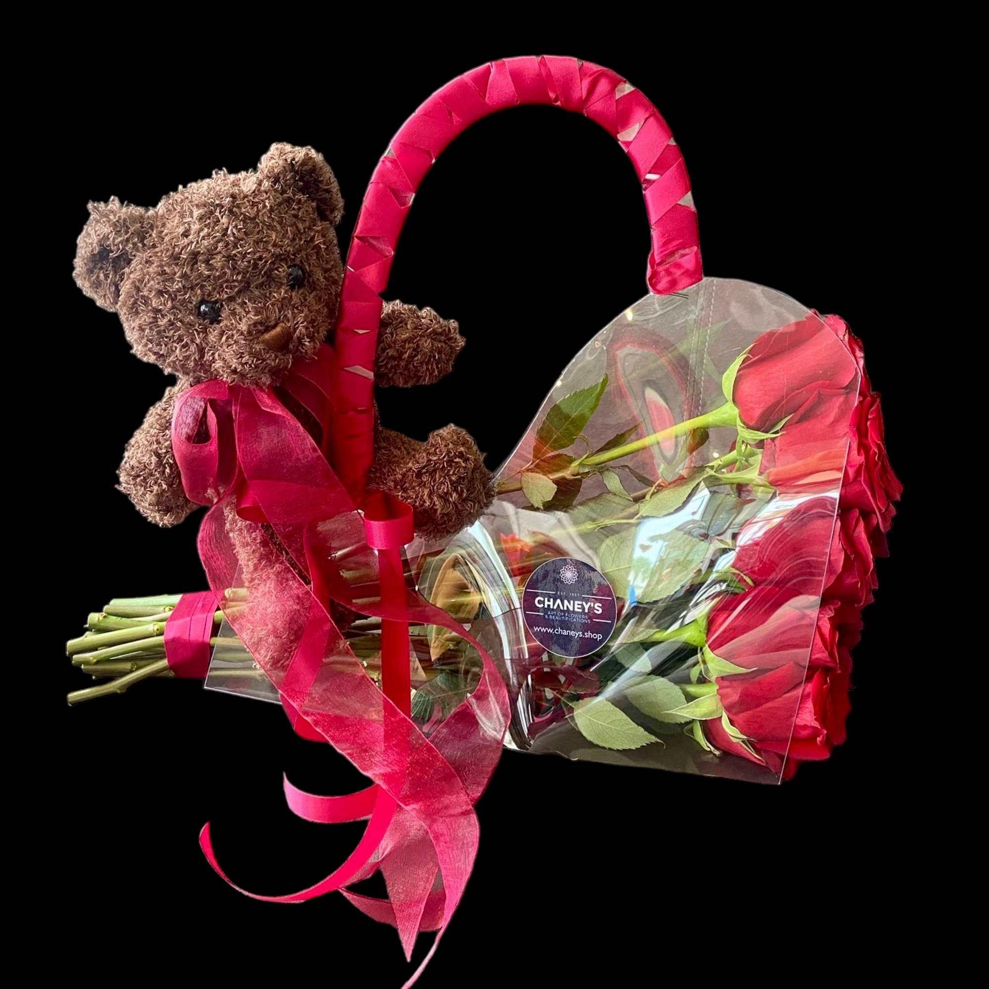 Teddy bear attached to a heart-shaped bouquet of red roses