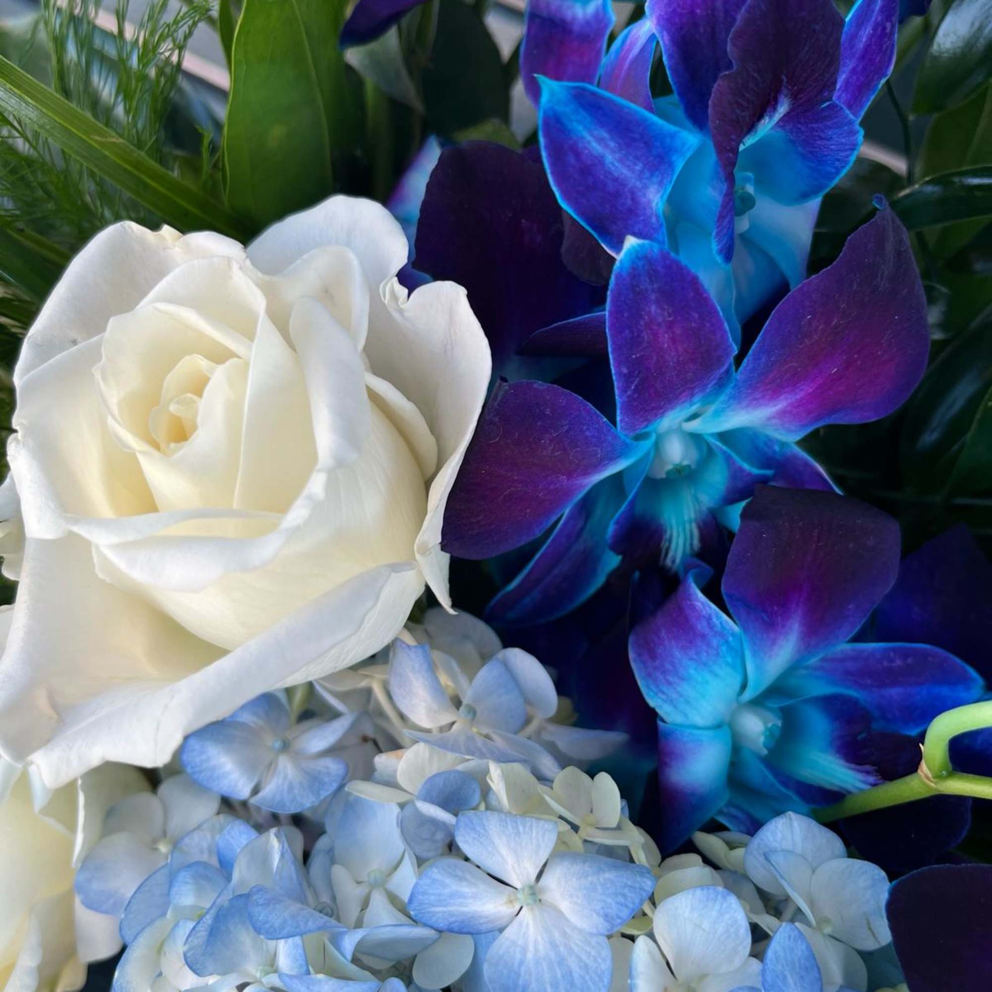 White rose with blue-purple orchids and pale blue hydrangea