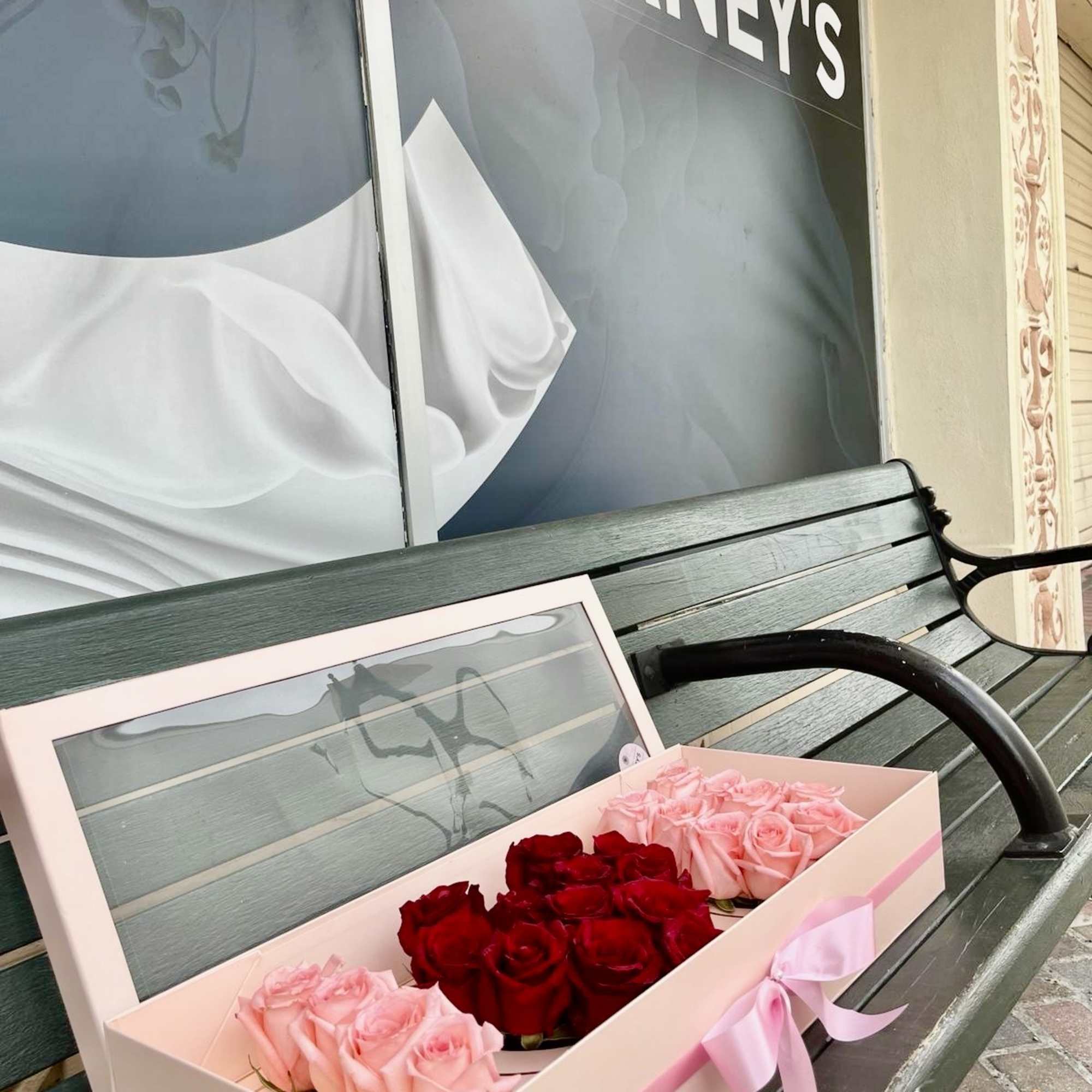 Box of pink and red roses with a pink ribbon