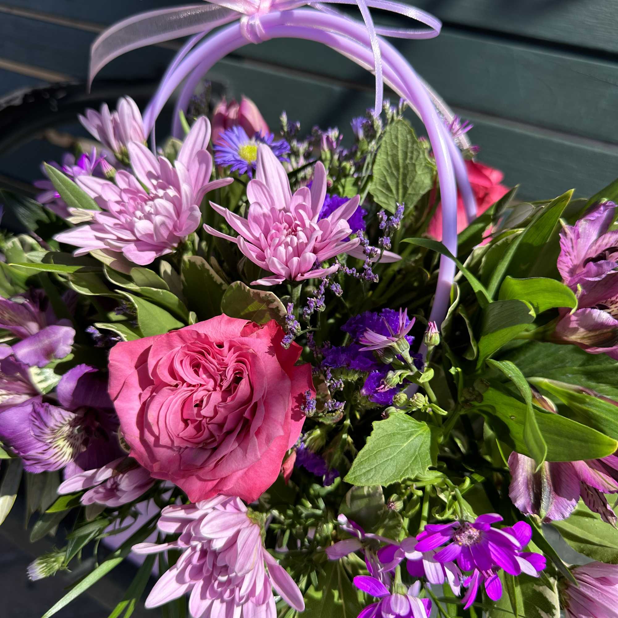 Pink and purple mixed flower basket with a ribbon handle