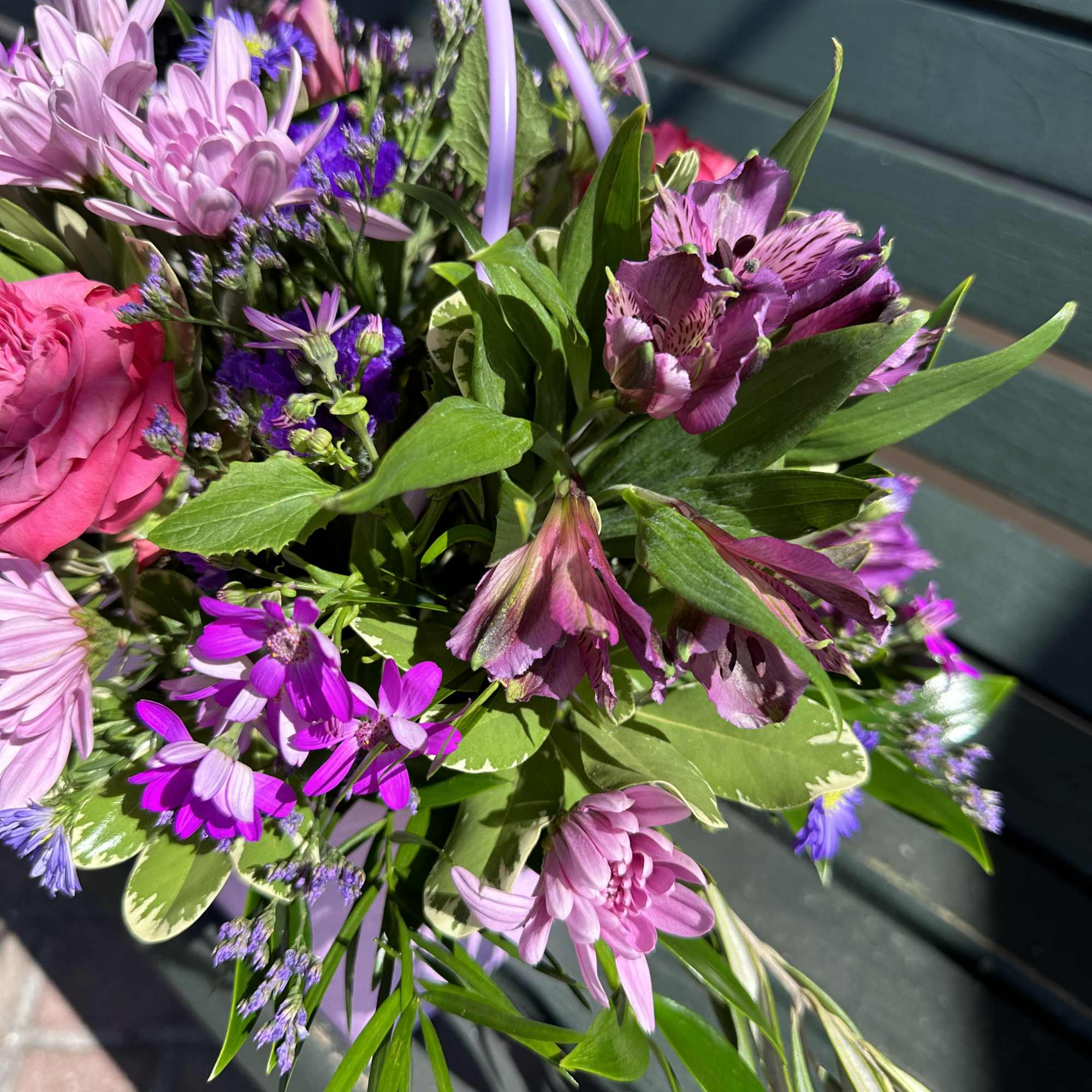 Mixed bouquet of pink and purple flowers tied with a lavender ribbon