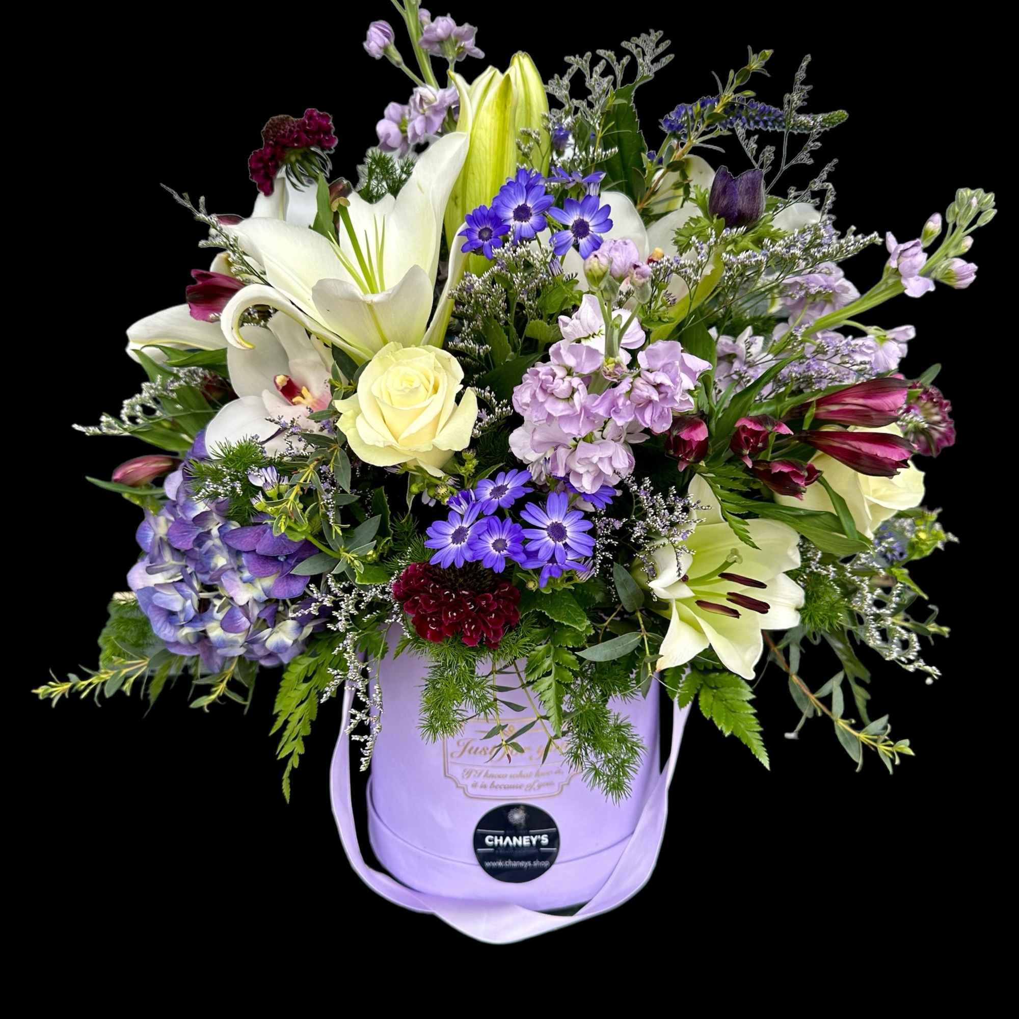 Lavender hatbox arrangement with lilies, roses, and purple daisies