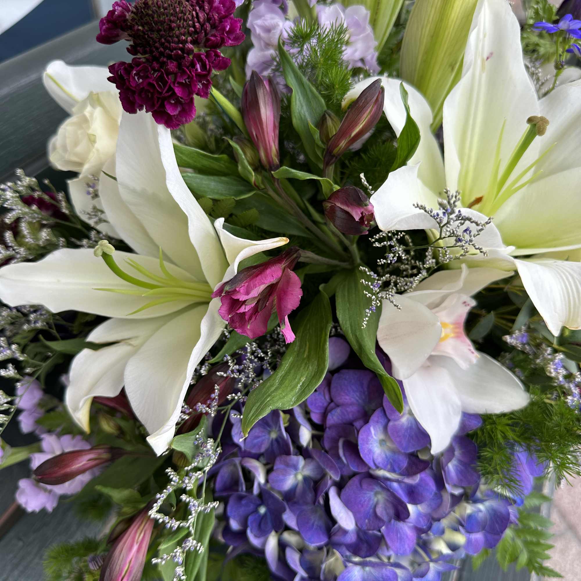 Bouquet of white lilies, purple hydrangea, and magenta blooms