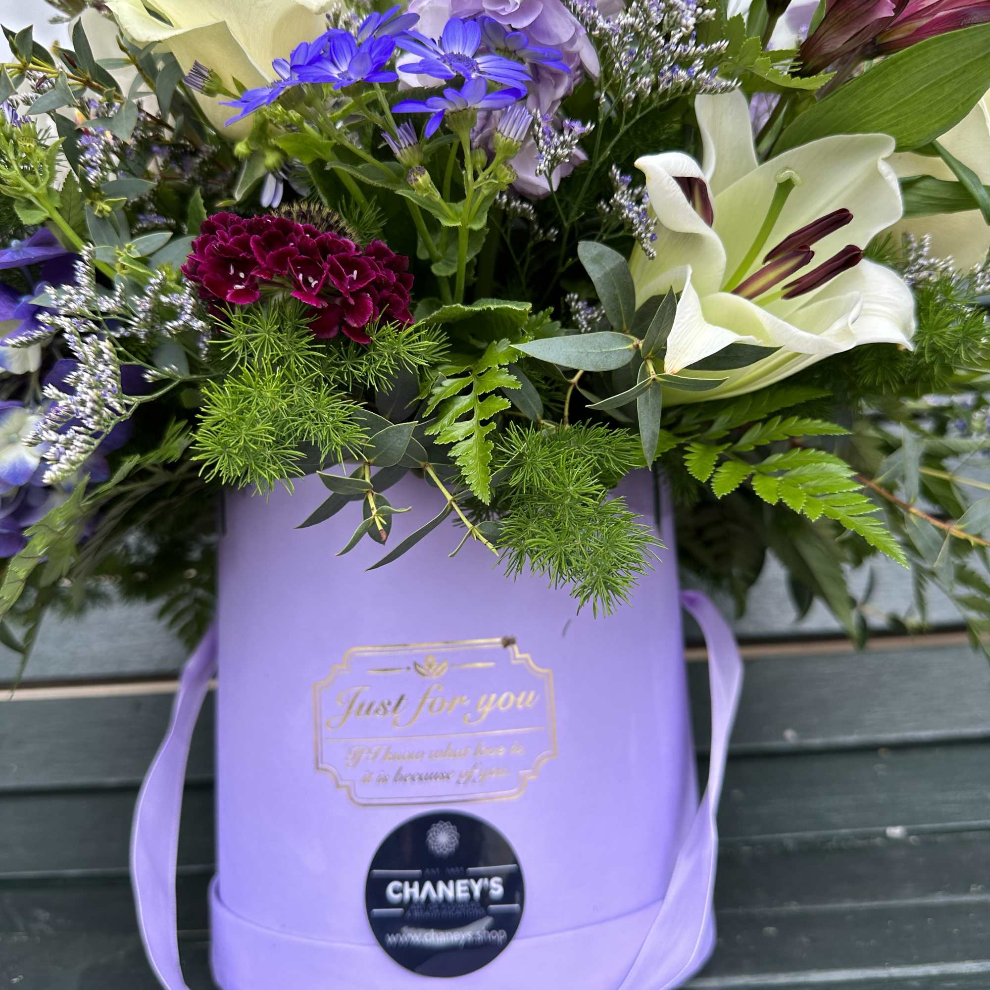 Mixed bouquet in a lavender gift box with lilies and purple flowers