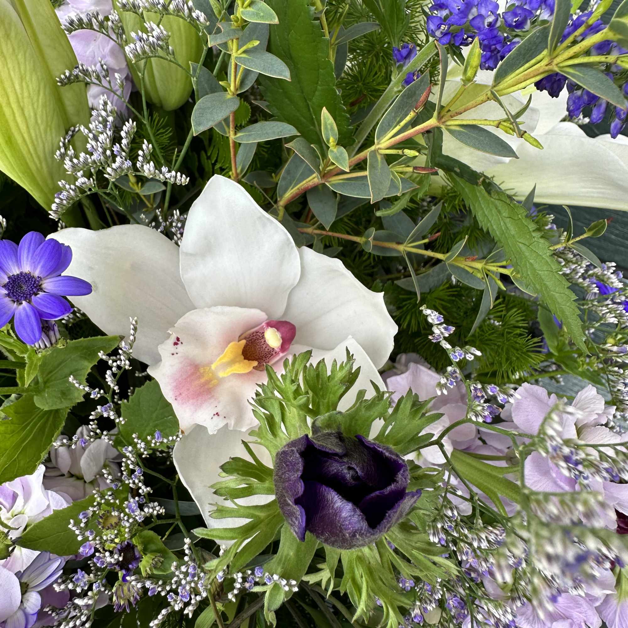 Purple and white mixed bouquet with orchids and other blooms