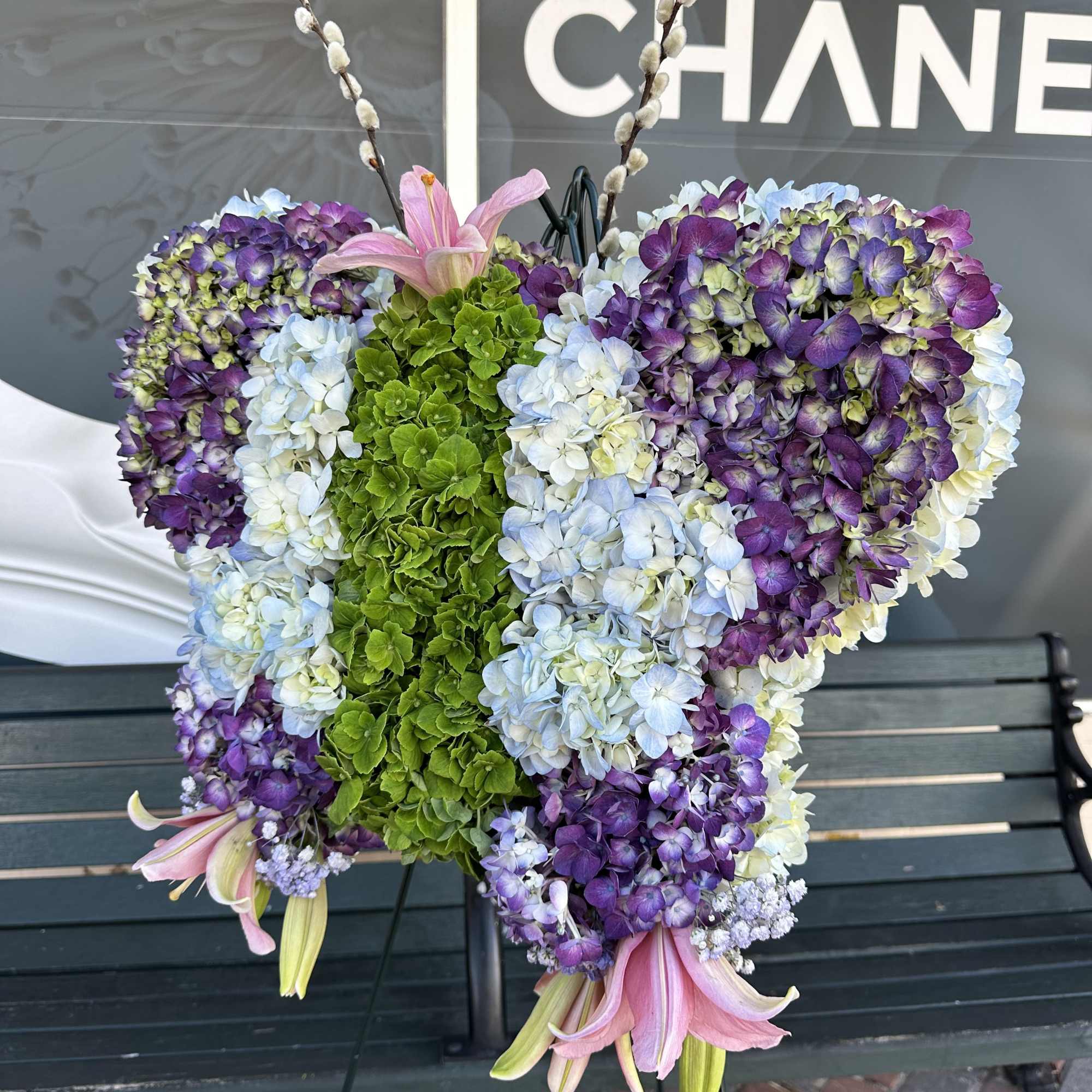 Butterfly-shaped floral arrangement with purple, blue, white, and green blooms