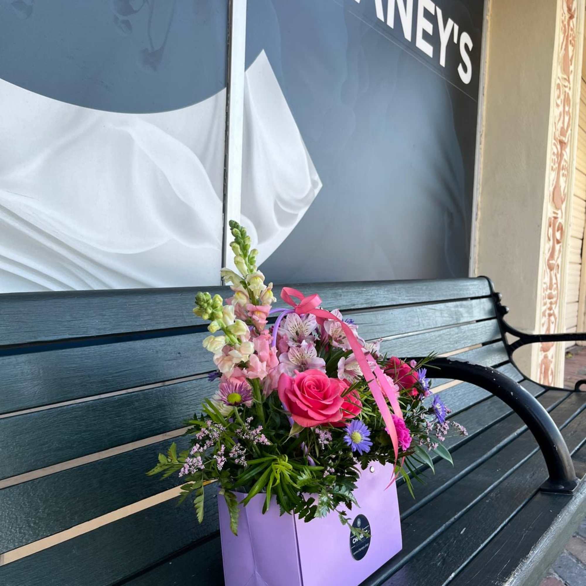 Pink rose bouquet in a lavender gift bag with ribbon