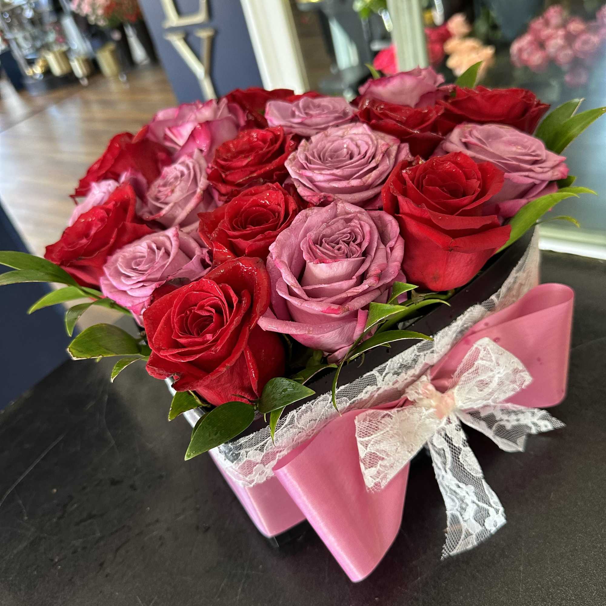 Pink and red roses in a pink gift box with lace ribbon