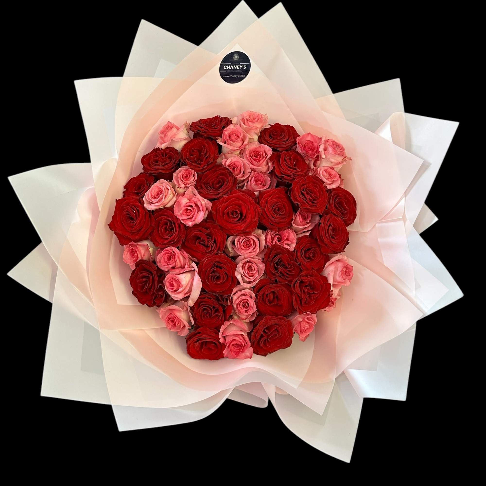 Bouquet of red and pink roses wrapped in pale paper