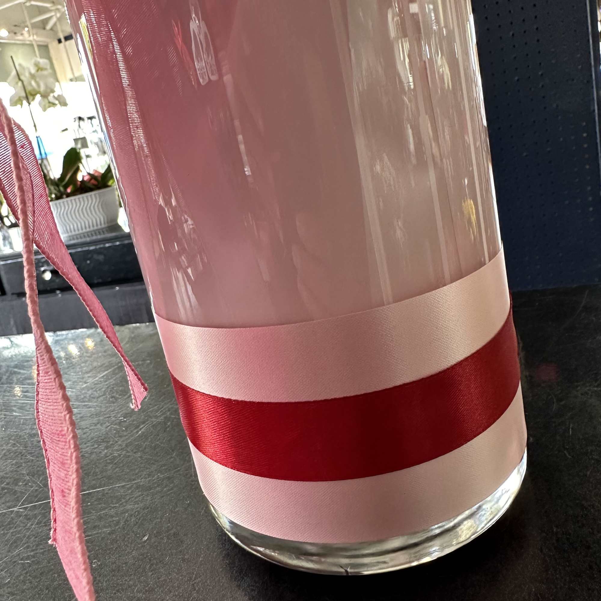 Clear glass vase wrapped with pink and red ribbon
