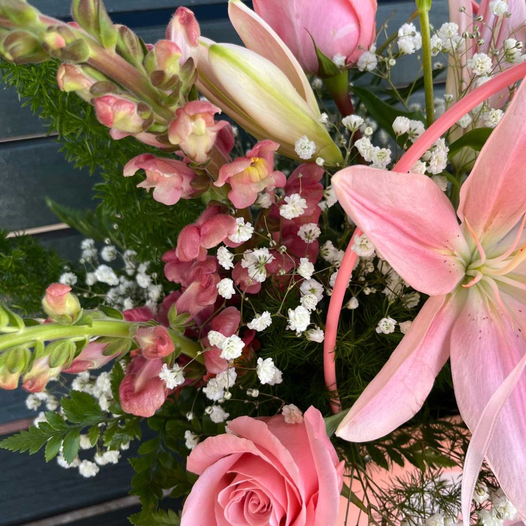 Pink roses and lilies with white baby's breath in a bouquet