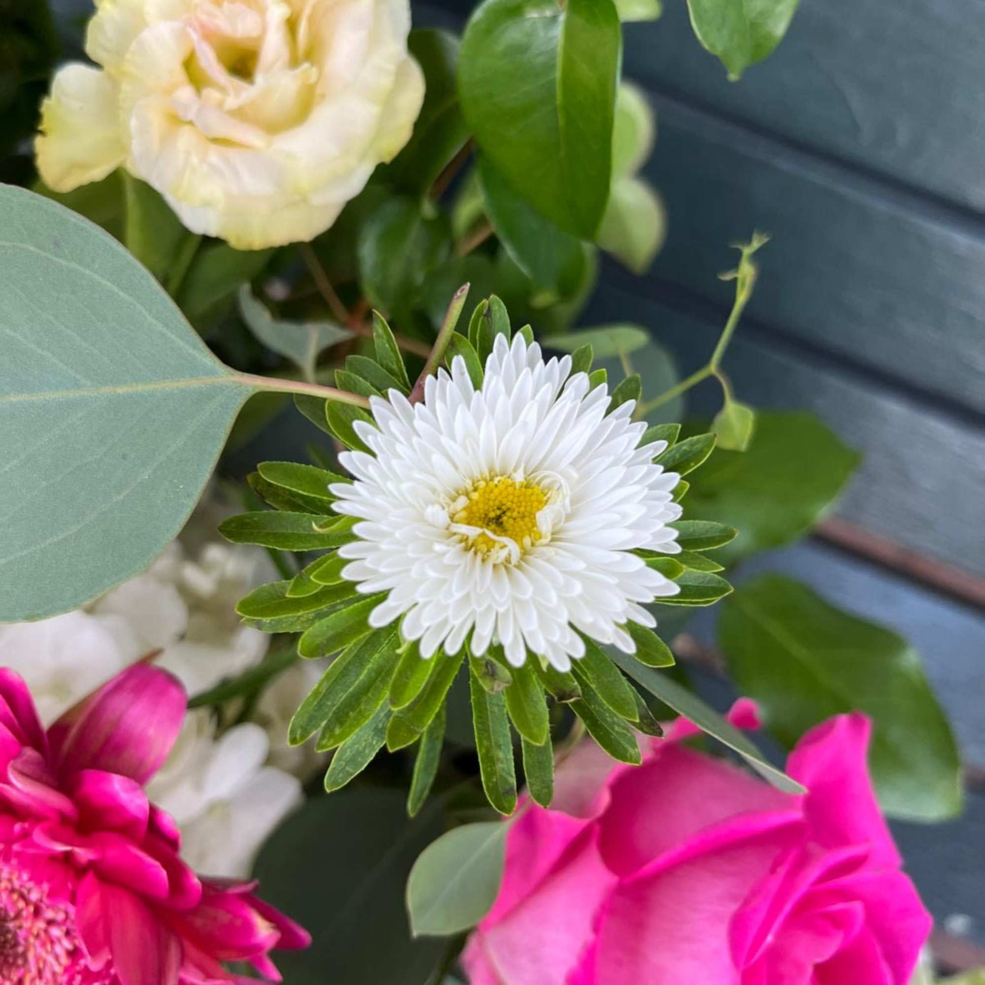 Mixed bouquet with a white daisy-like bloom, pink rose, and pale yellow flower
