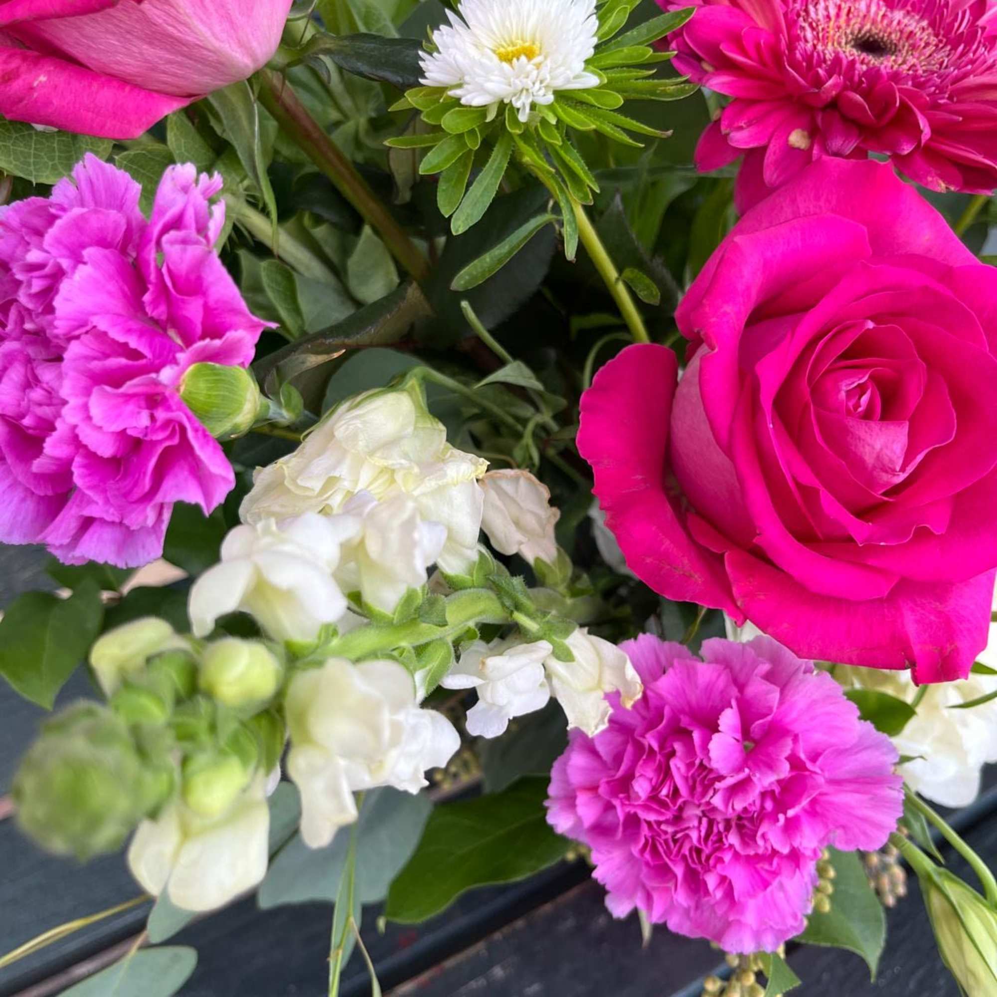 Bouquet of hot pink roses, carnations, and white blooms