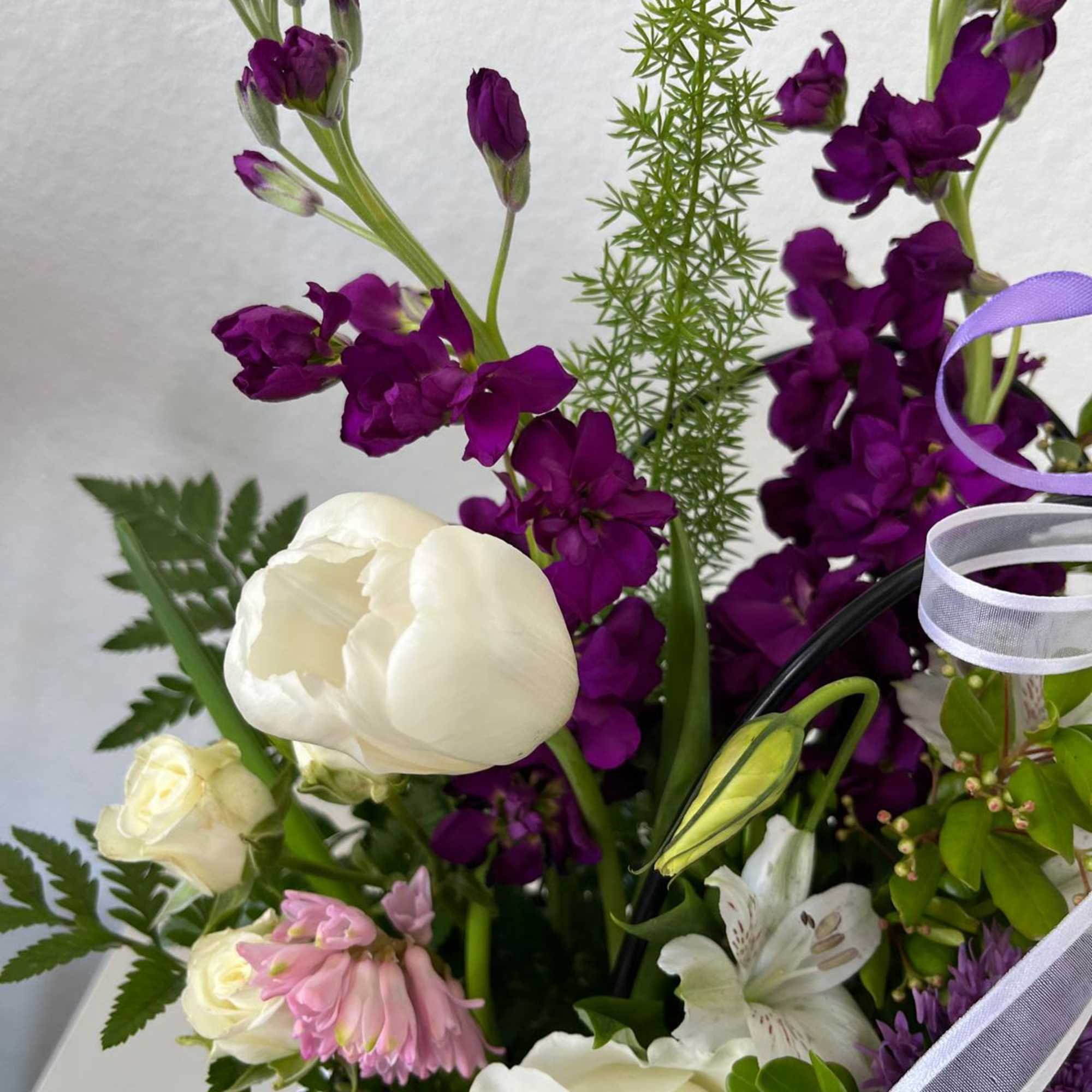 Bouquet of white and purple flowers with ribbon accents