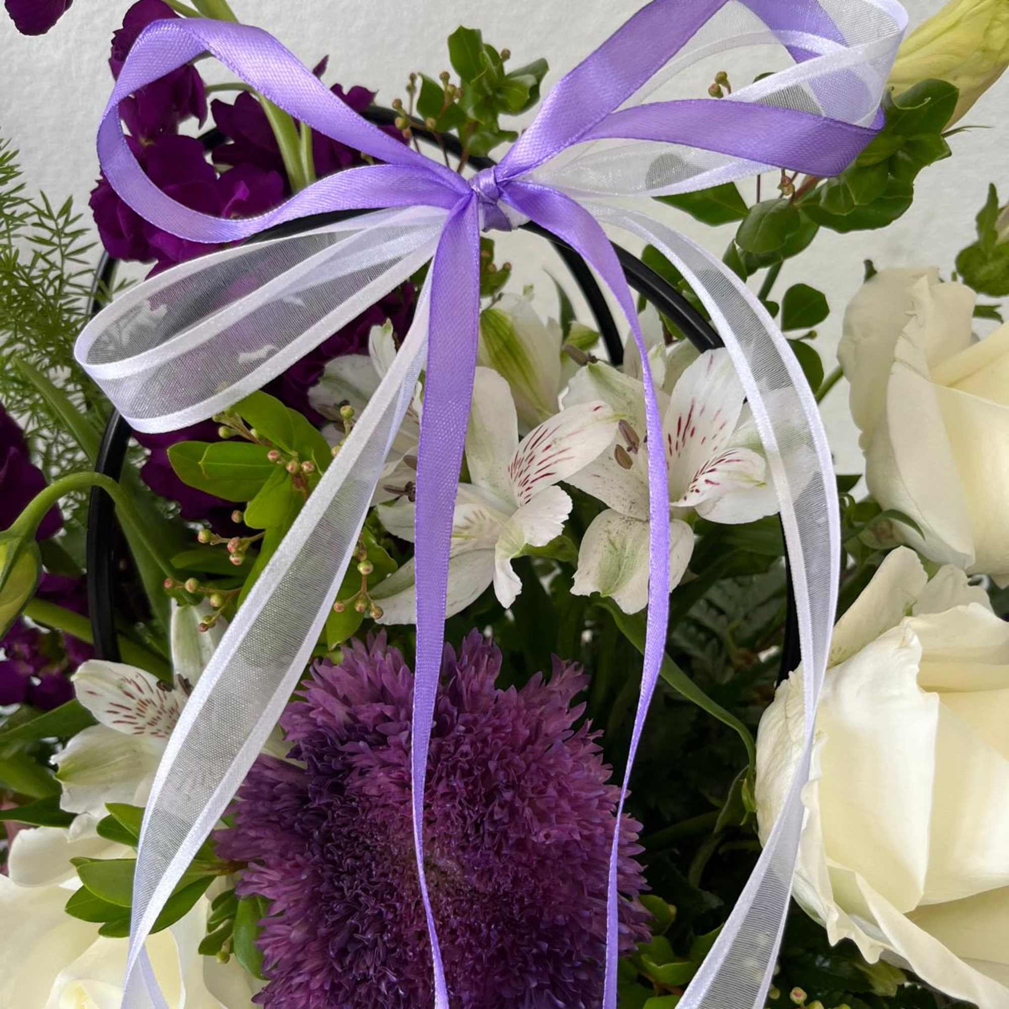 Purple and white floral bouquet tied with a lavender ribbon