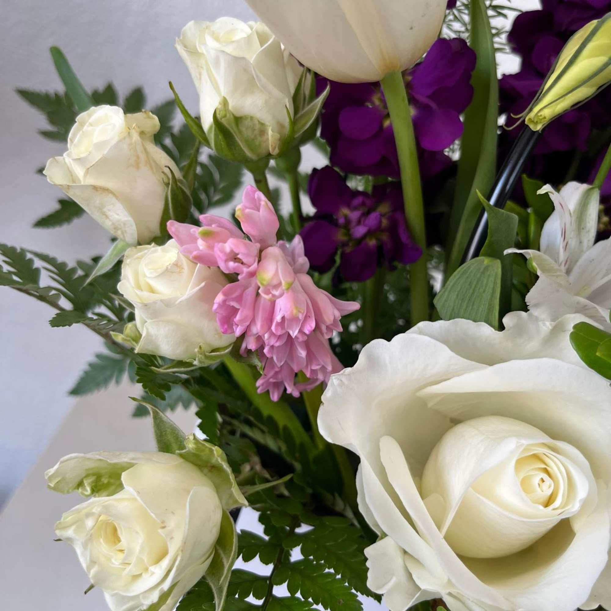 Bouquet of white roses, pink hyacinth, and purple flowers
