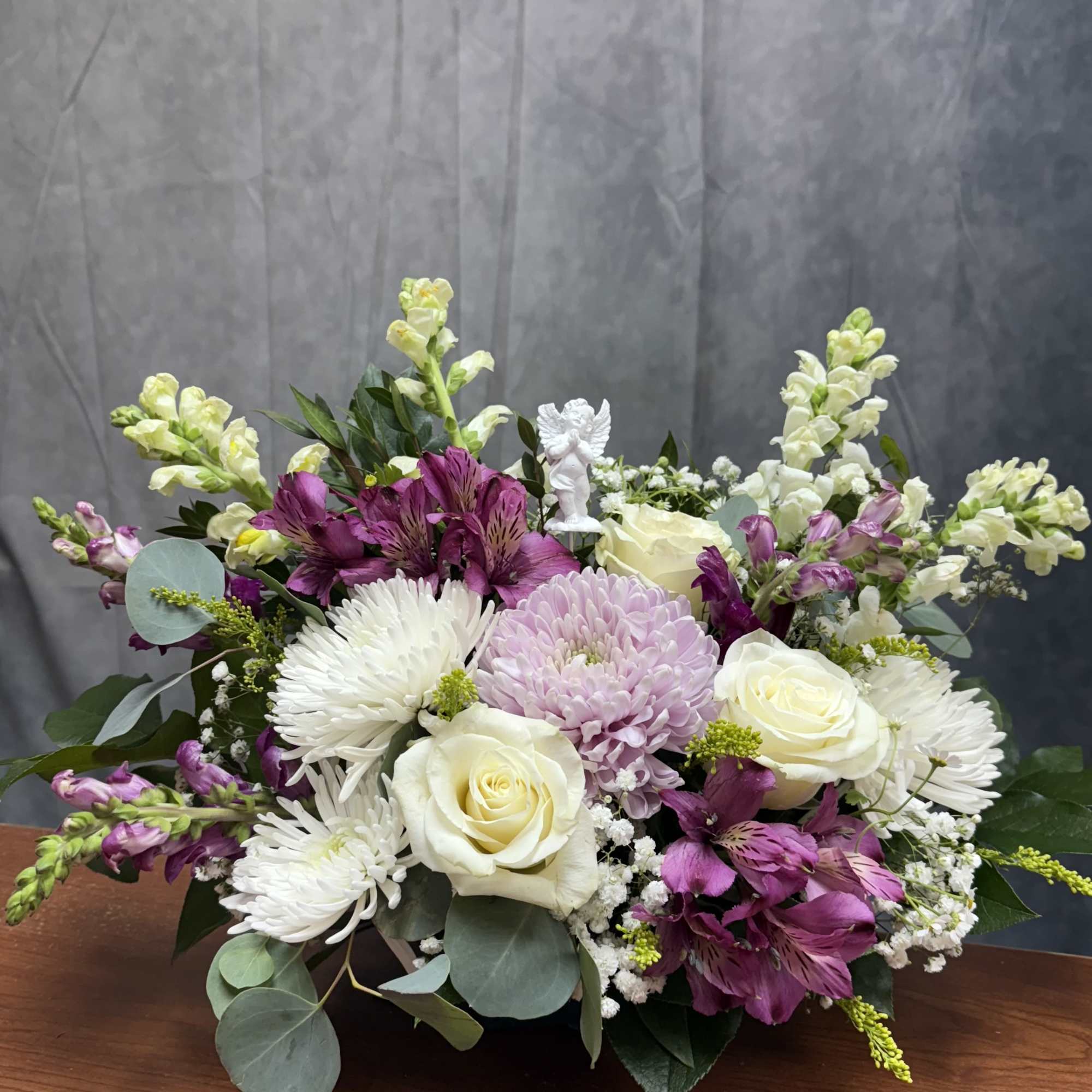 Mixed bouquet of white and purple flowers in a low container