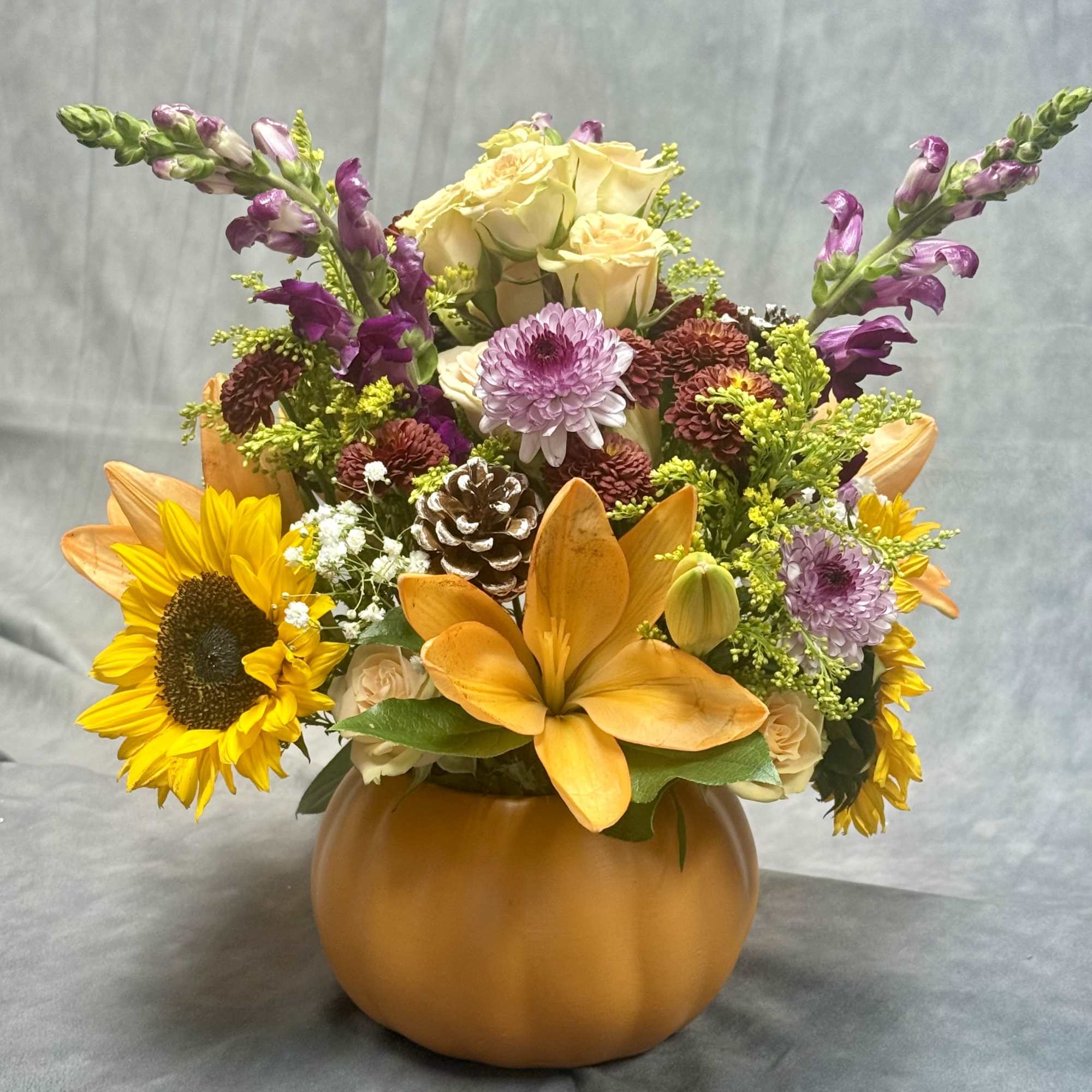 Bring fall into your home with this vibrant pumpkin arrangement filled with