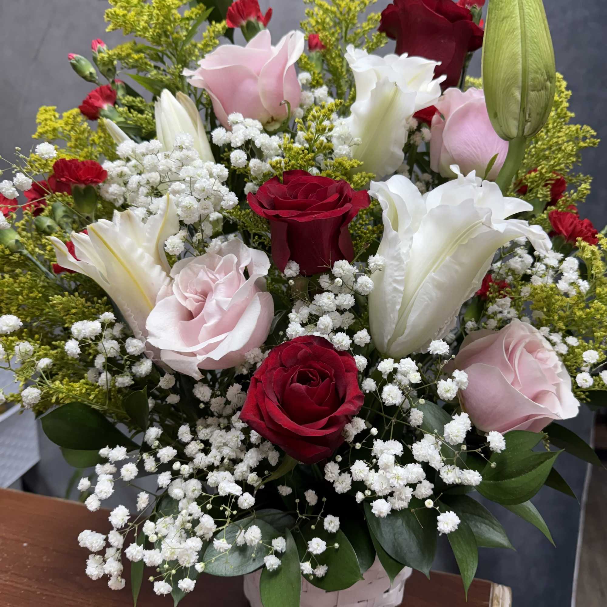 Red, pink and white roses and lilies with red carnations, baby's breath