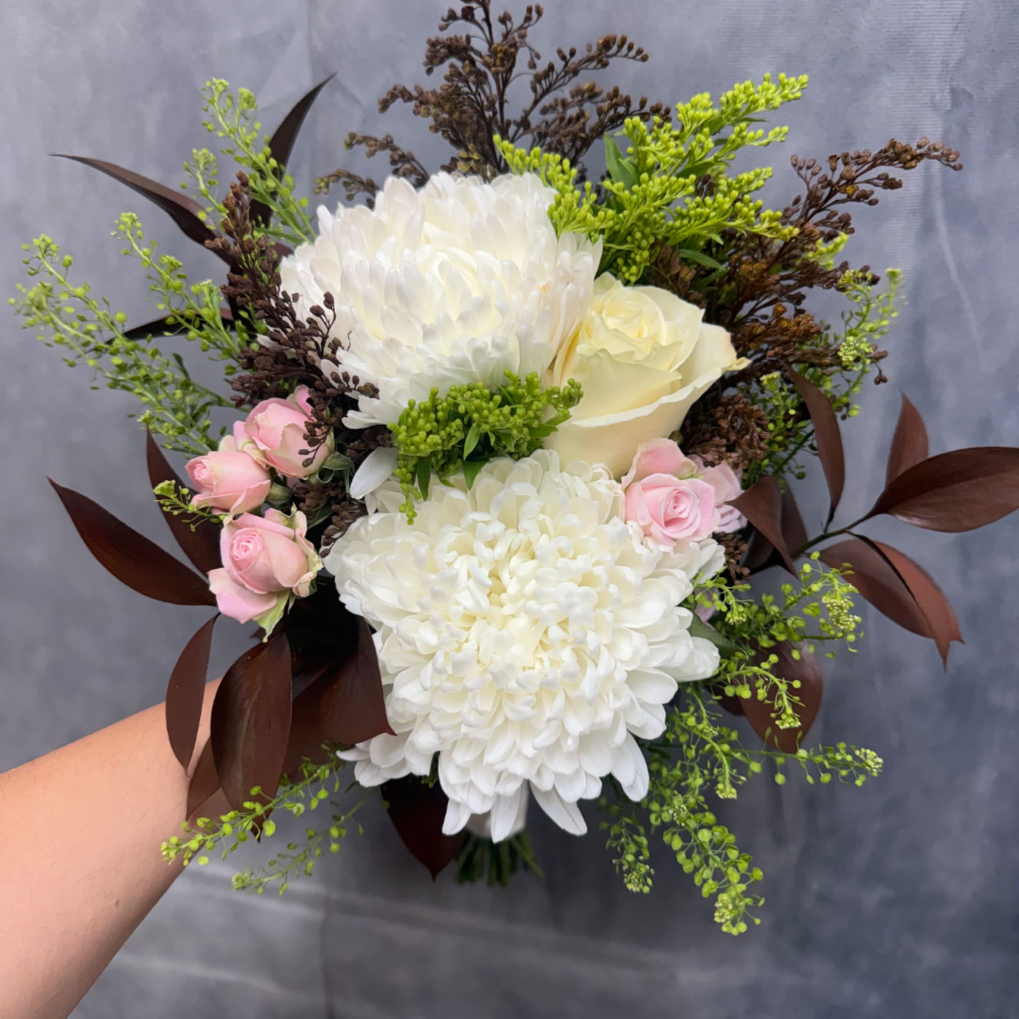 Bouquet of white chrysanthemums, pale roses, and pink spray roses