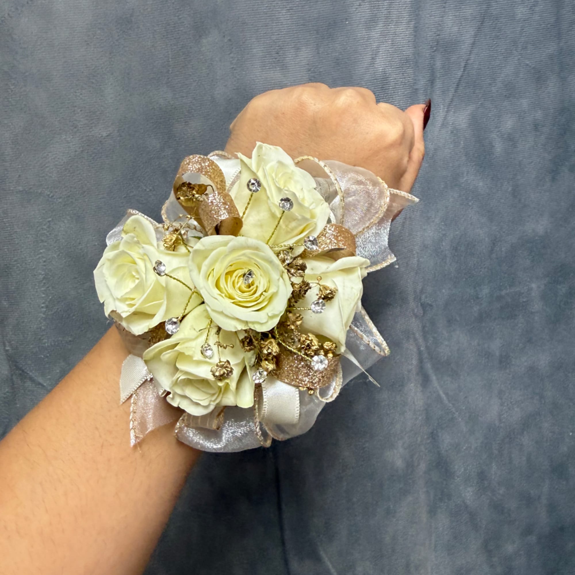 Cream rose wrist corsage with gold ribbon and rhinestone accents