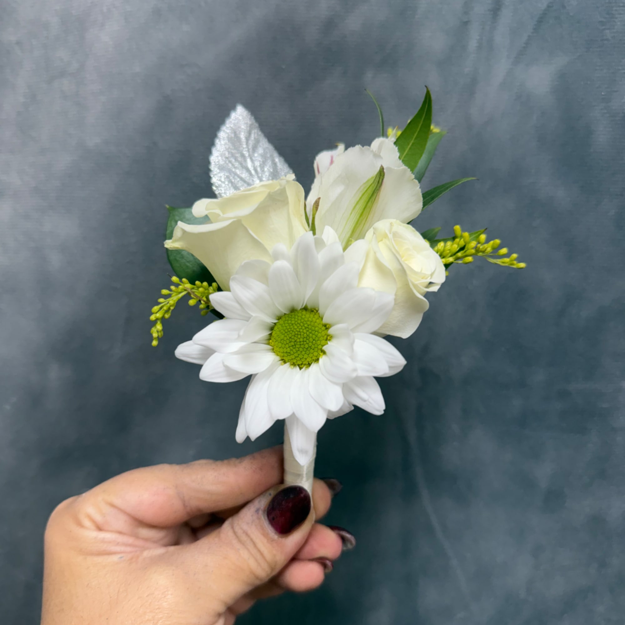 White boutonniere with a daisy and roses held in hand, photo 2 of 2