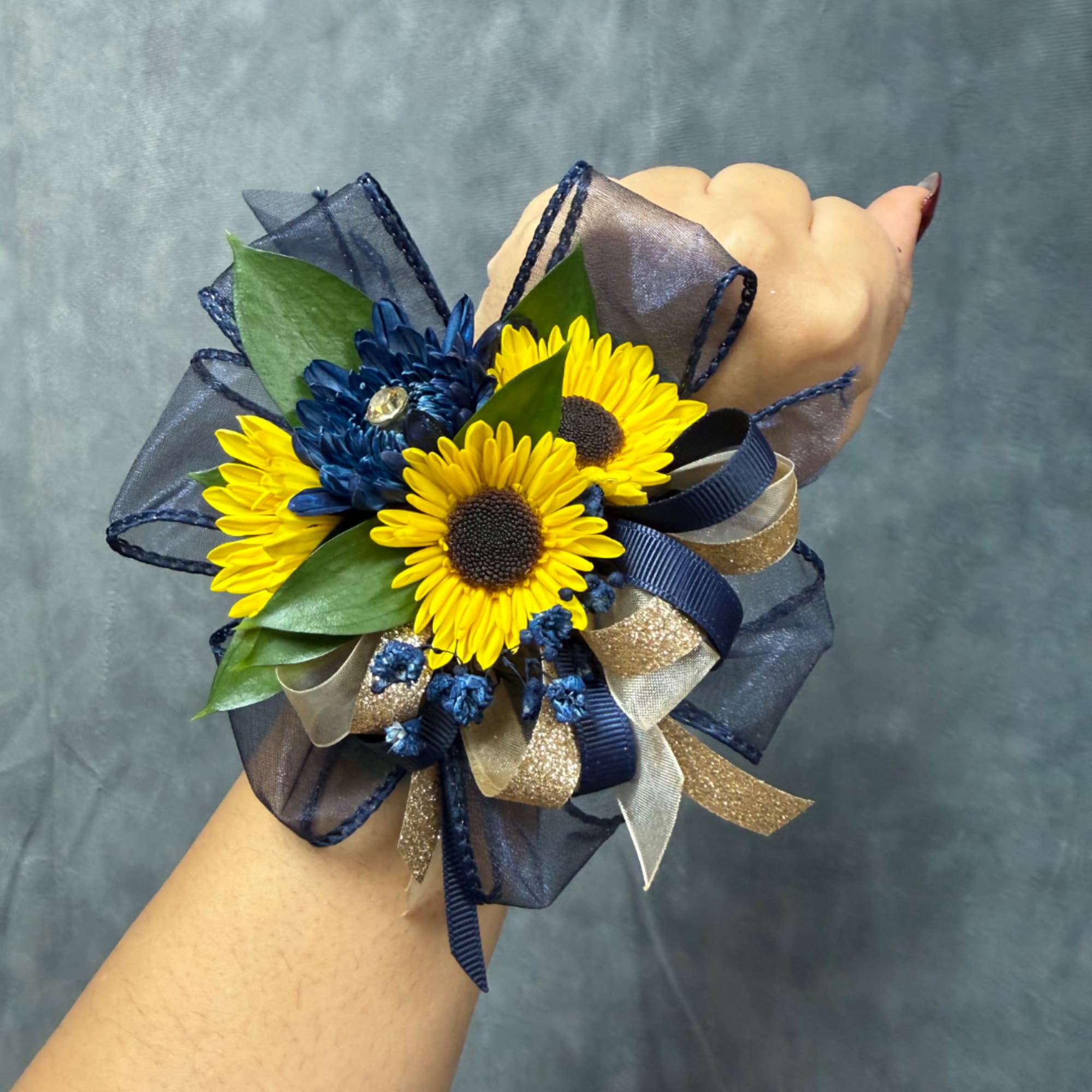 Wrist corsage with yellow daisies and blue flowers on ribbon