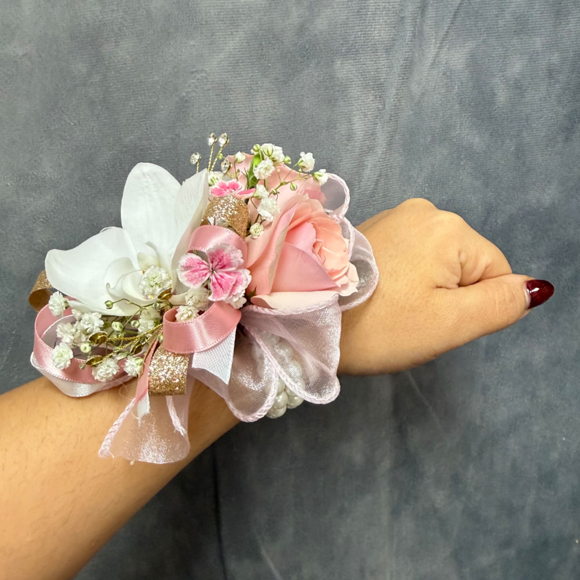 Pink and white wrist corsage with ribbon and small flowers