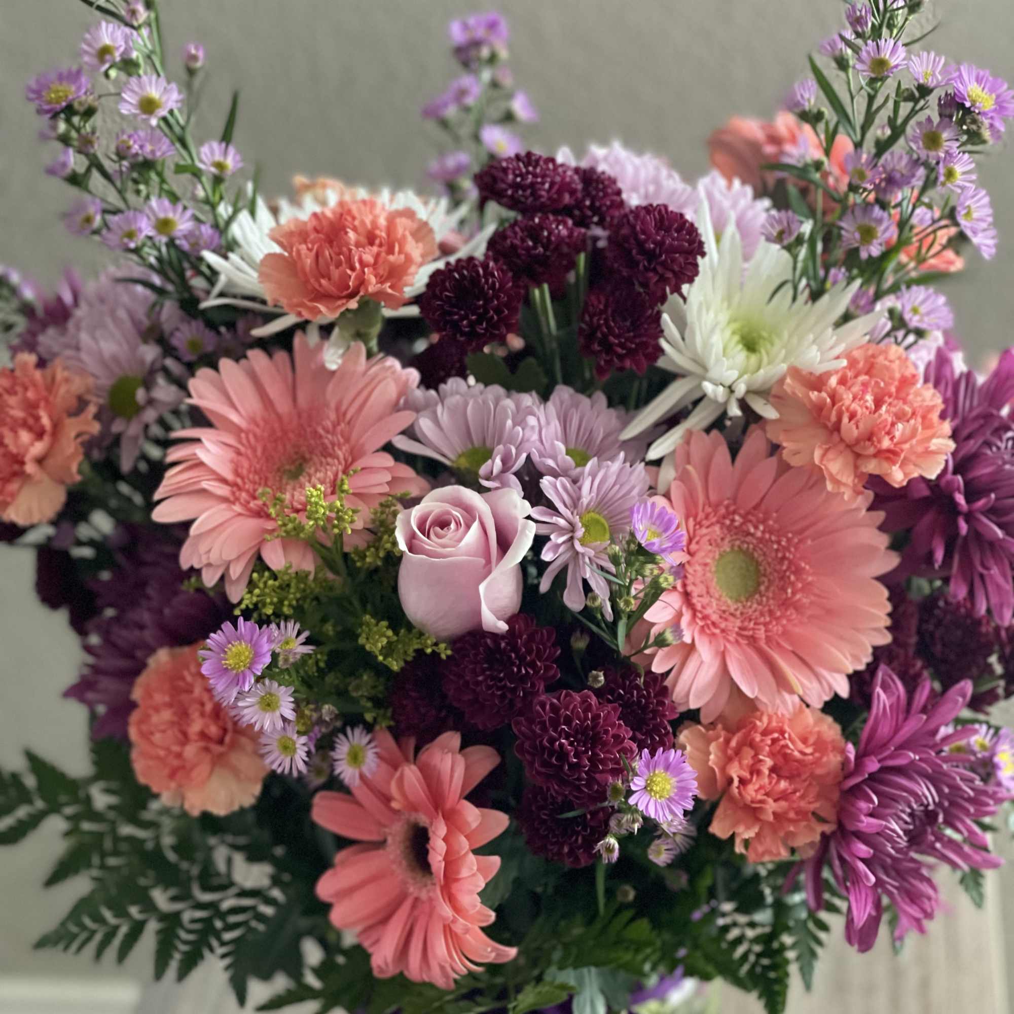 Mixed bouquet of pink, purple, and white flowers with a lavender rose