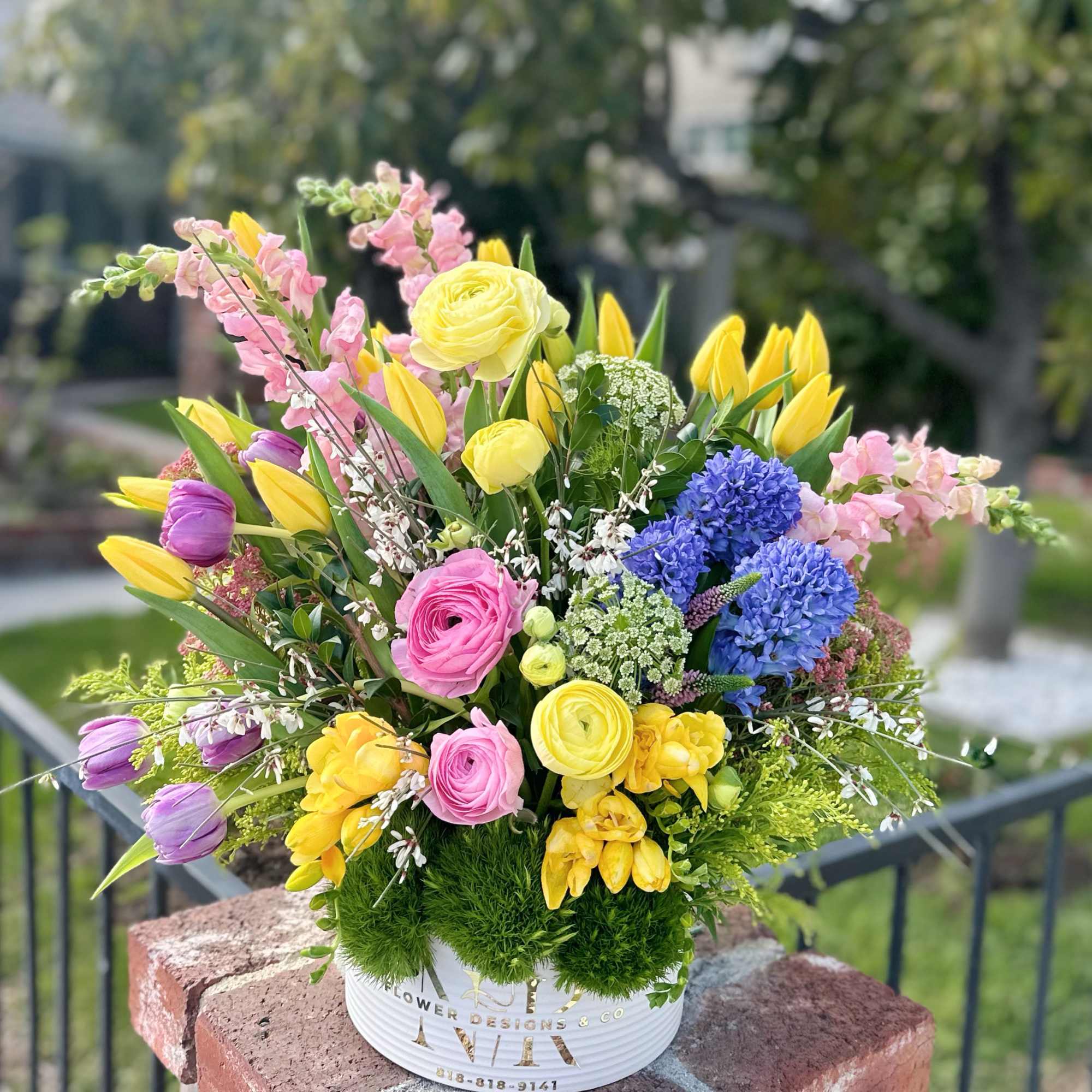 Purple, pink, yellow, white flowers with bright greens in between assembled in