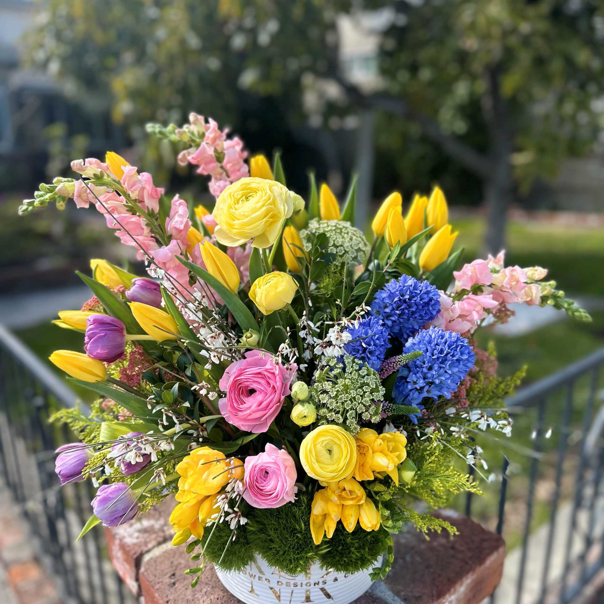 Purple, pink, yellow, white flowers with bright greens in between assembled in, photo 2 of 2