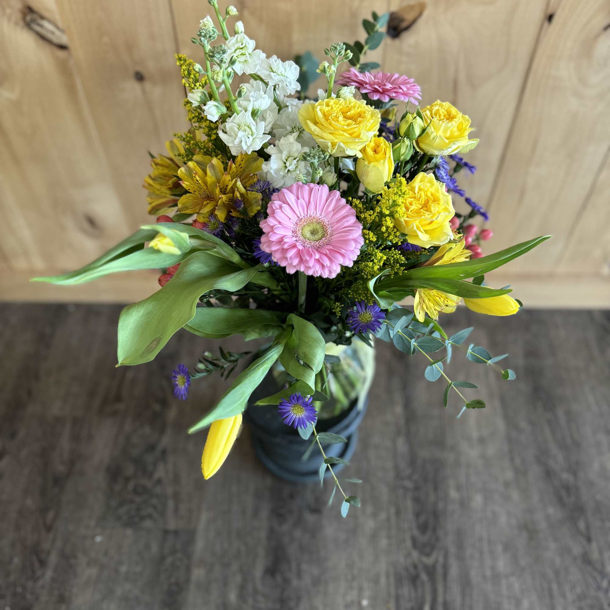 Mixed bouquet with pink gerbera, yellow roses, and white stock in a vase
