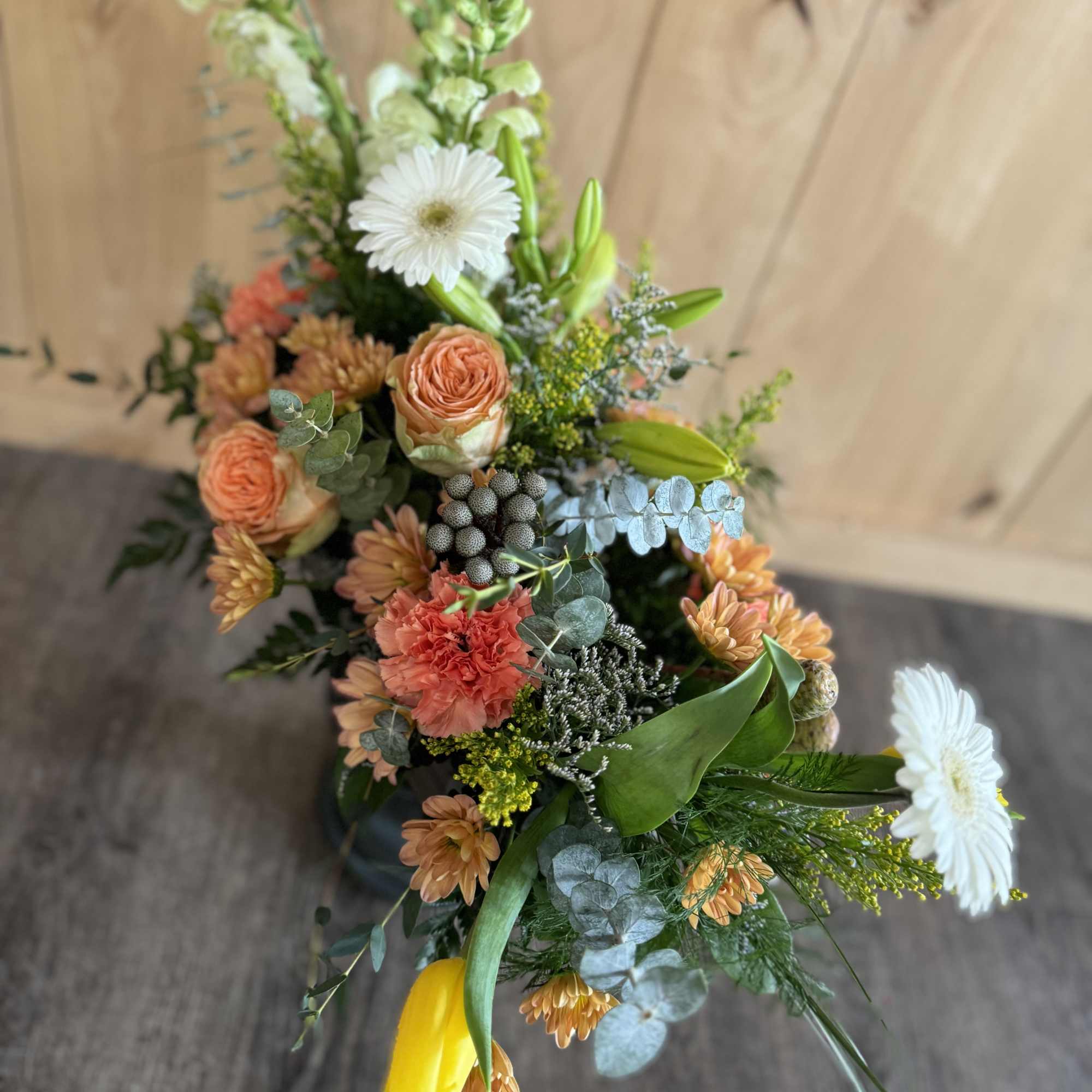 Mixed bouquet with white daisies, peach roses, and yellow tulips