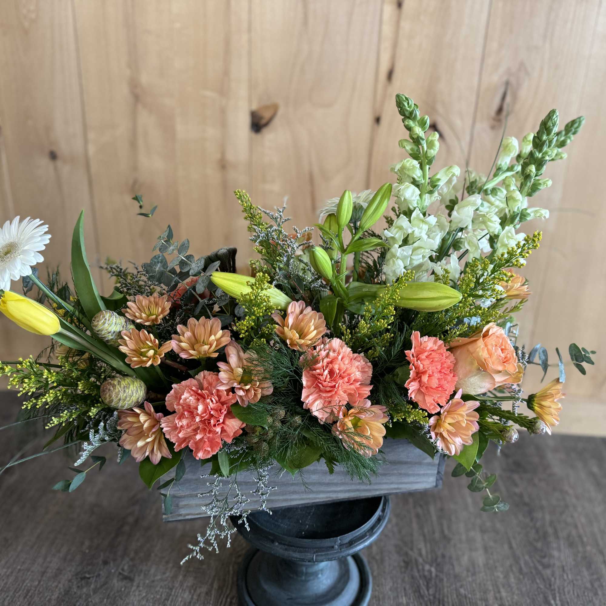 Mixed floral arrangement in a rectangular container with white daisy and peach blooms